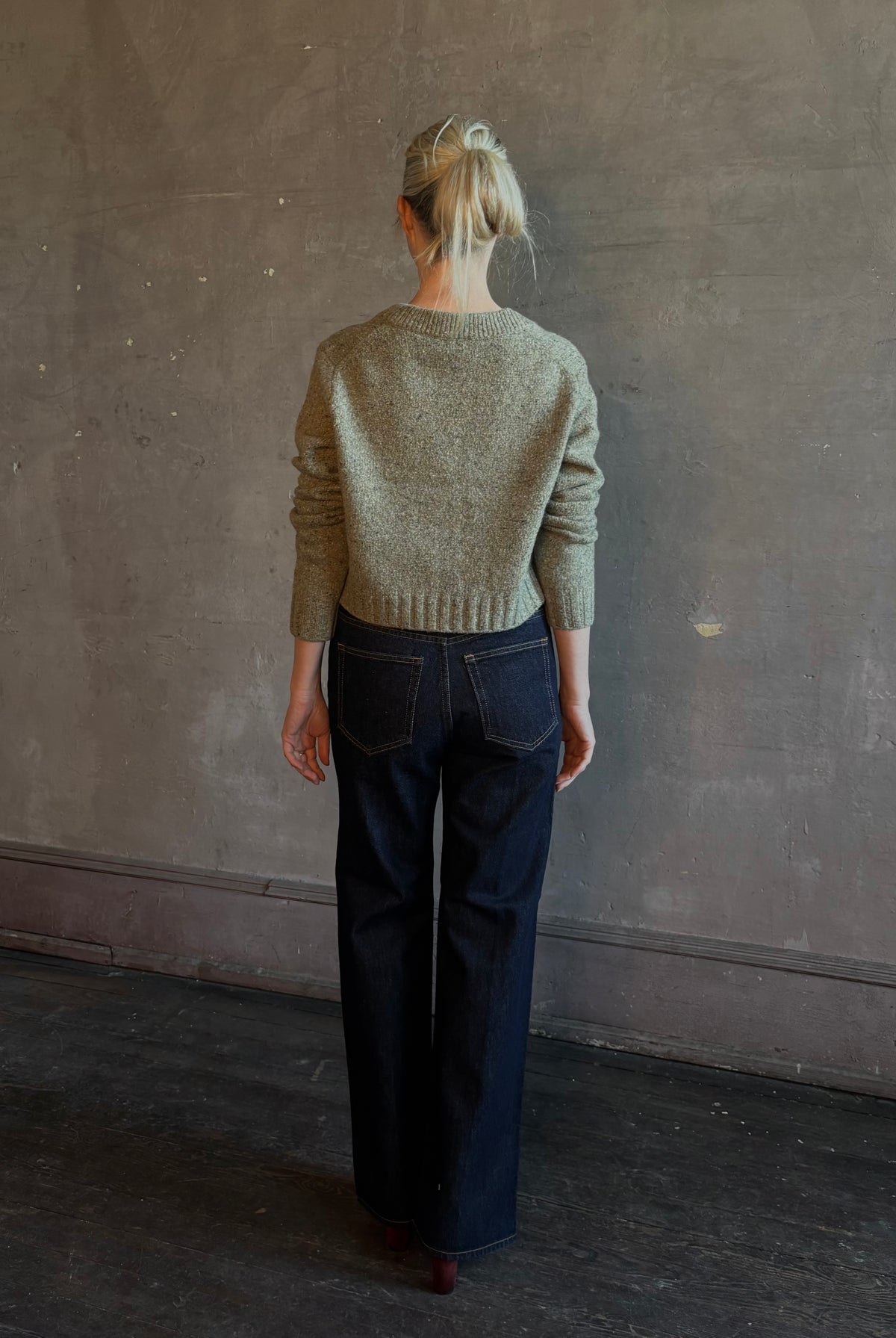 Mature woman wearing Rachel Comey Uridge Cardigan in Stone Green RWS-certified merino blend with U-neckline everyday layering