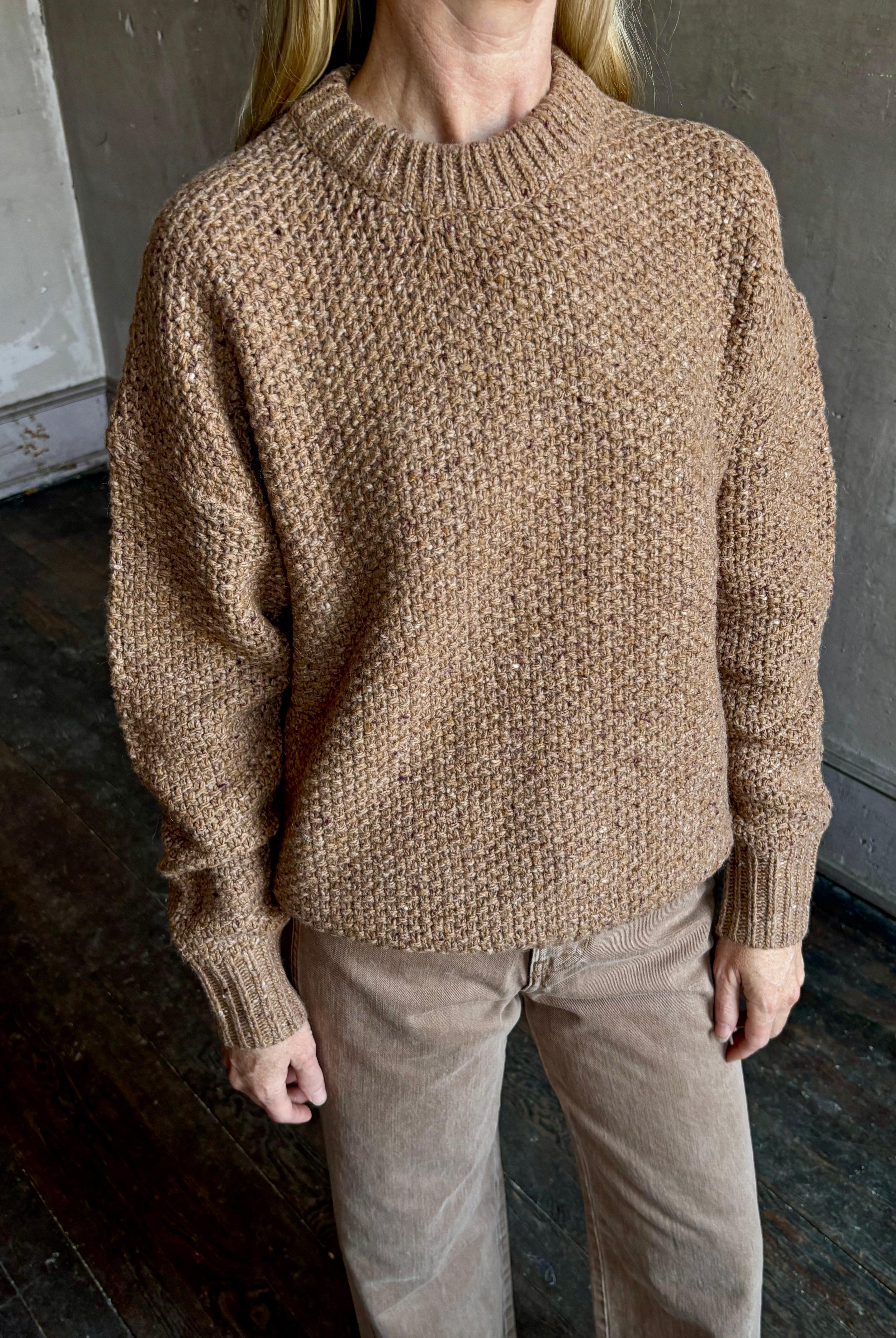 Image of mature woman wearing American designer Rachel Comey prescot sweater in a warm neutral colorway made with fine merino wool