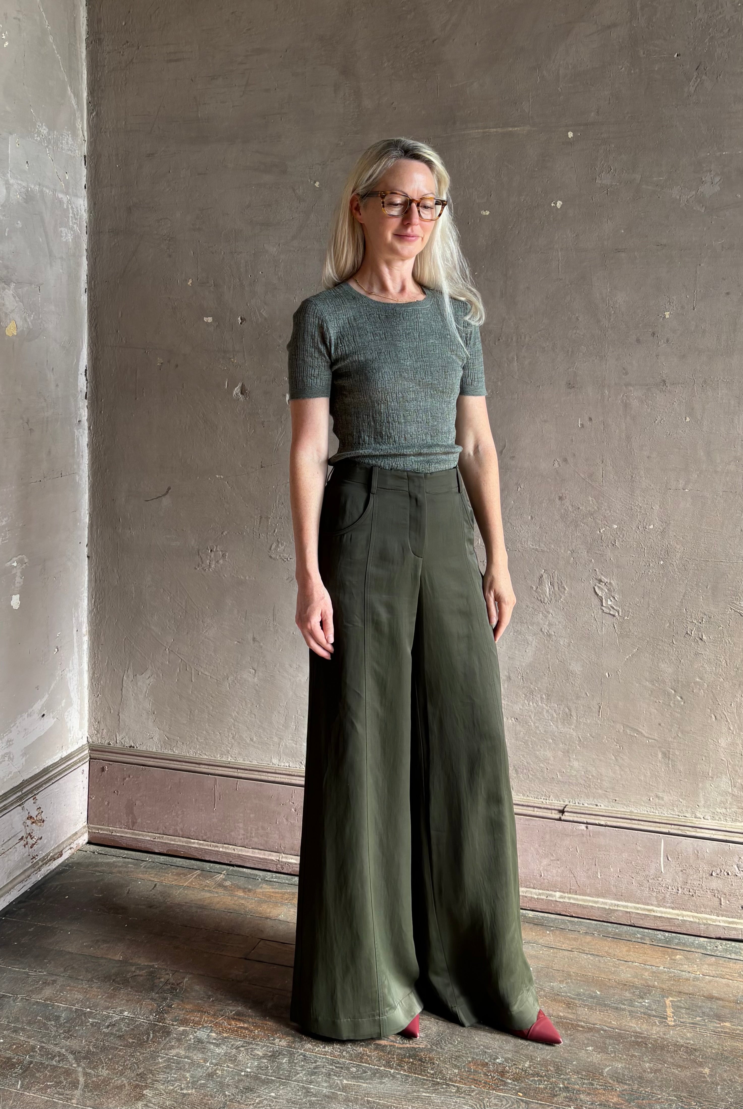 Mature woman wearing a textured short-sleeve fitted knit top in sage green round neckline with brown heathering