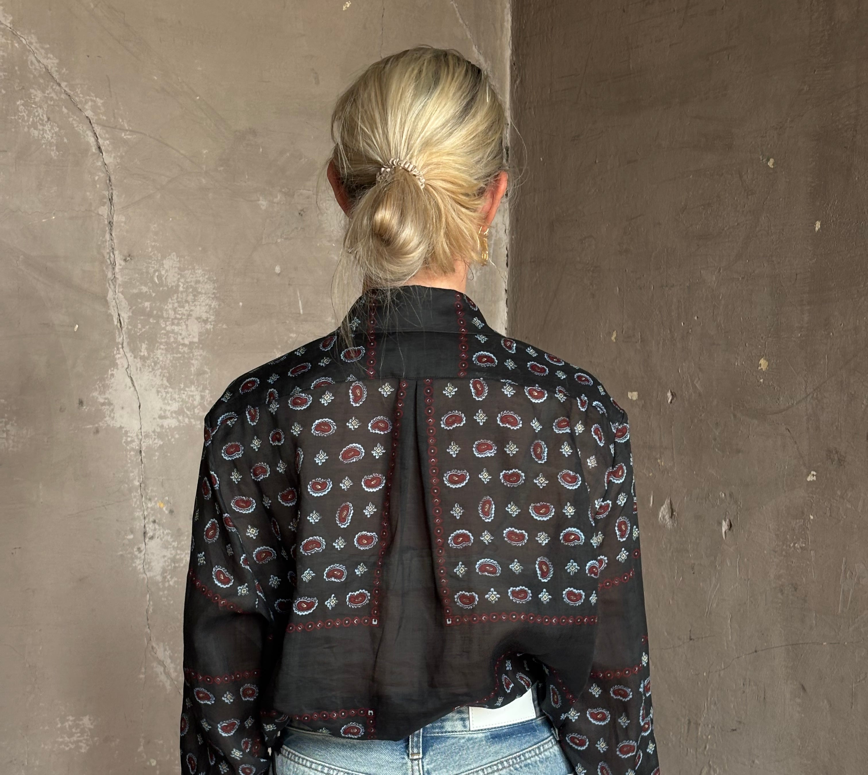 Mature woman wearing designer brand Rachel Comey long sleeve paisley print button down shirt semi-transparent
