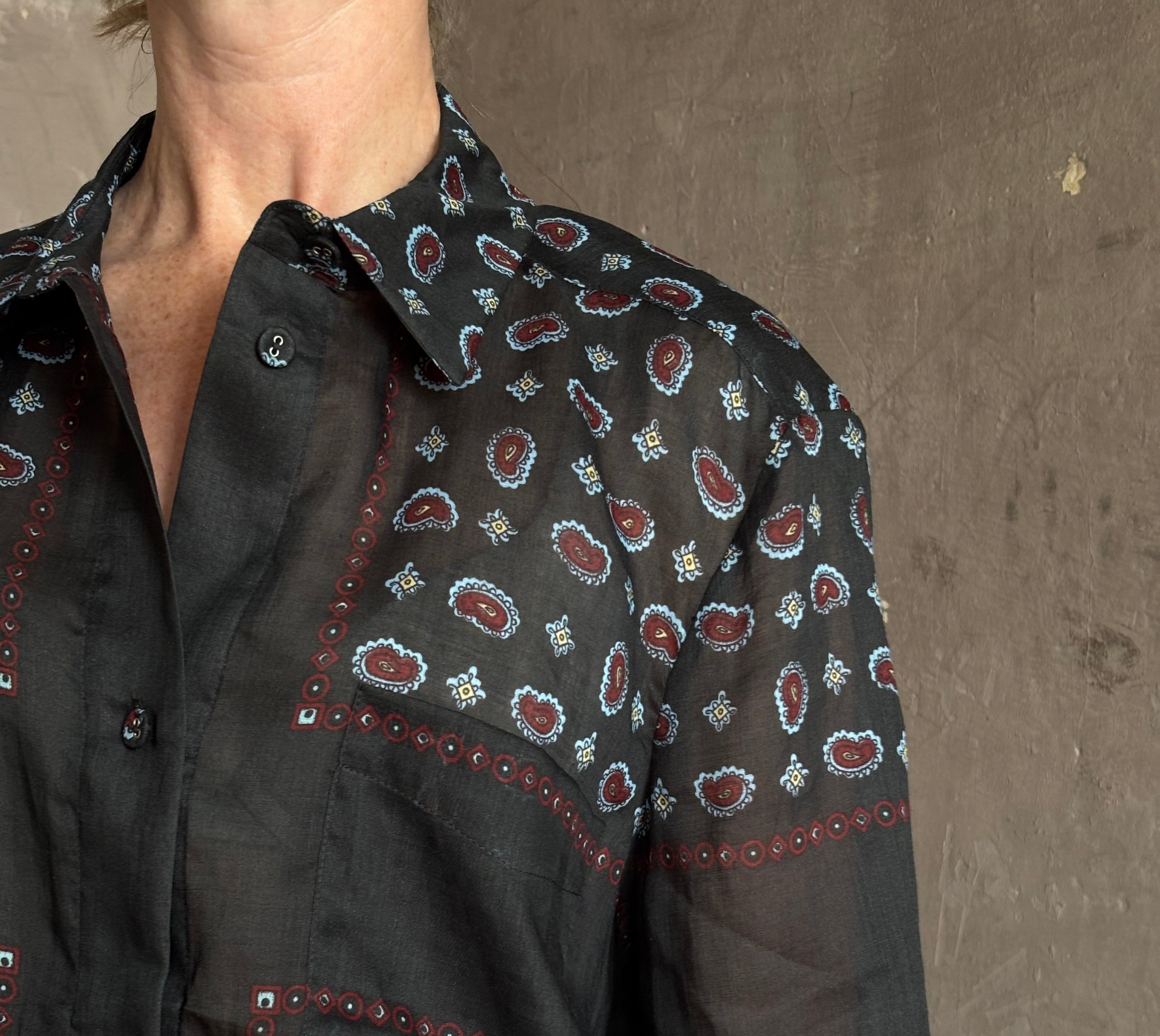 Mature woman wearing designer brand Rachel Comey long sleeve paisley print button down shirt semi-transparent