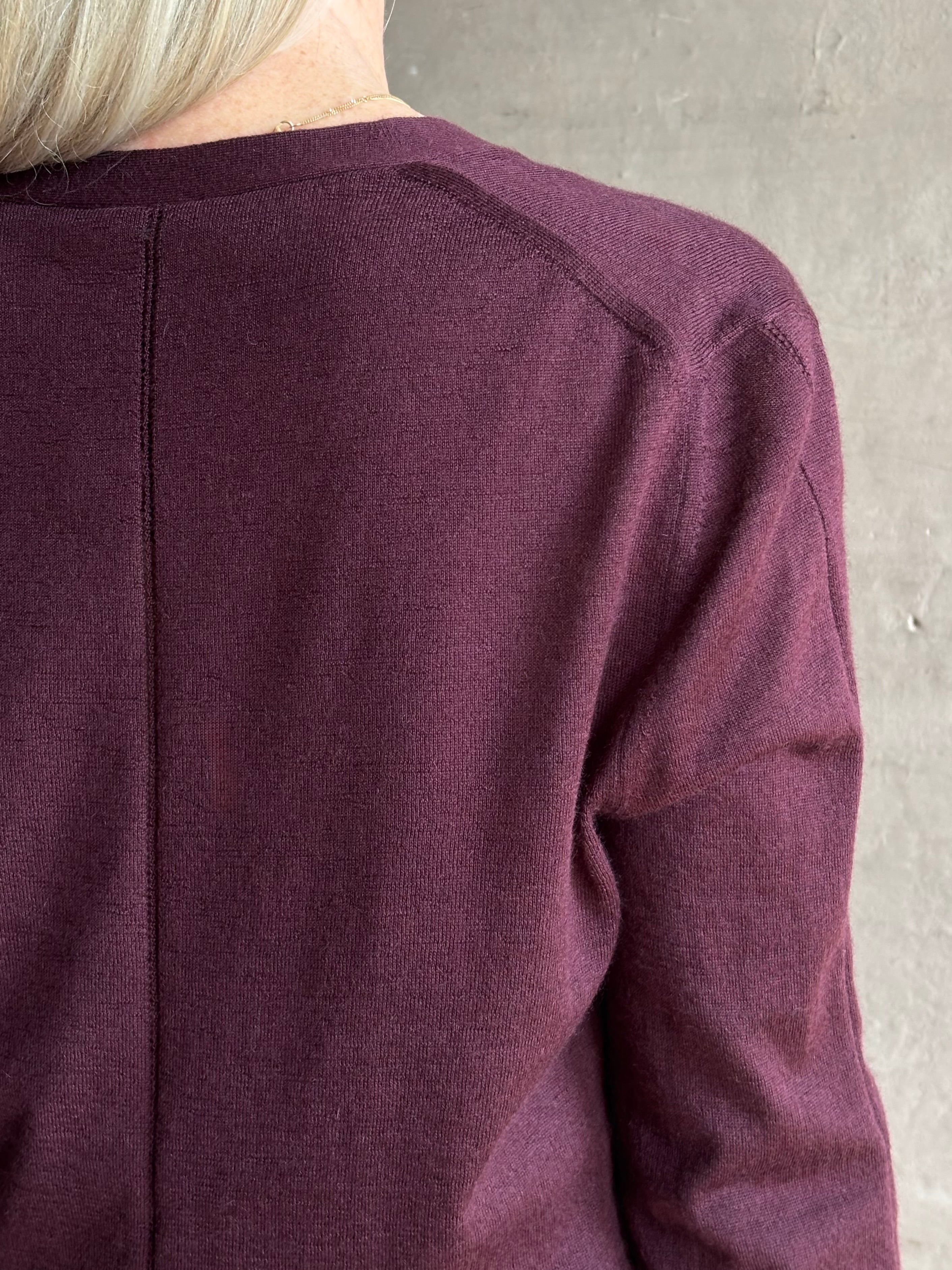 Mature woman wearing Rachel Comey long sleeve burgundy cardigan leightweight plunging v-neck layering