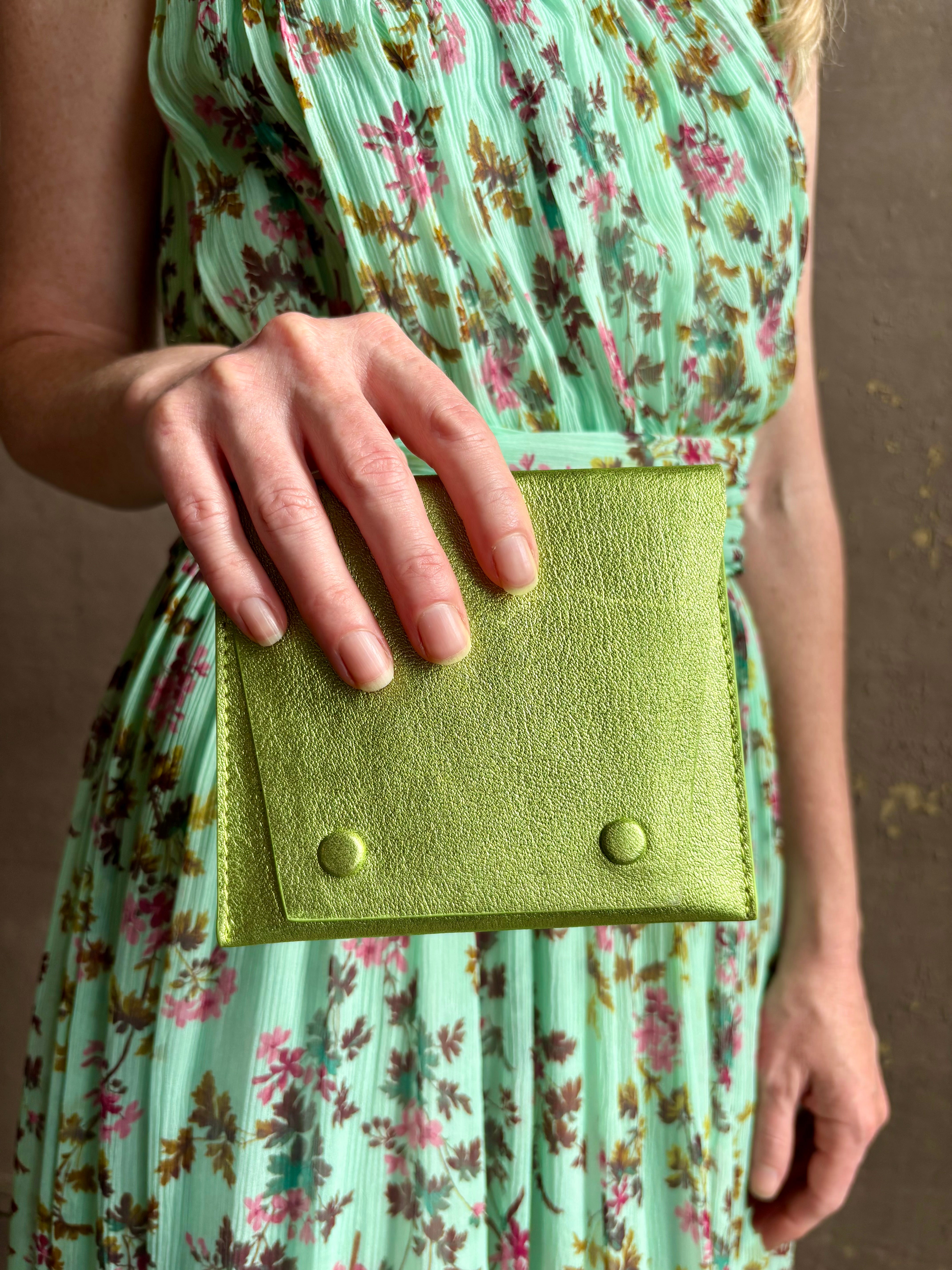 Woman holding Lime Wallet from Rachel Comey is a beautifully refined luxury accessory that is an everyday carry pieces. Crafted from 100% premium metallic leather to organize your purse