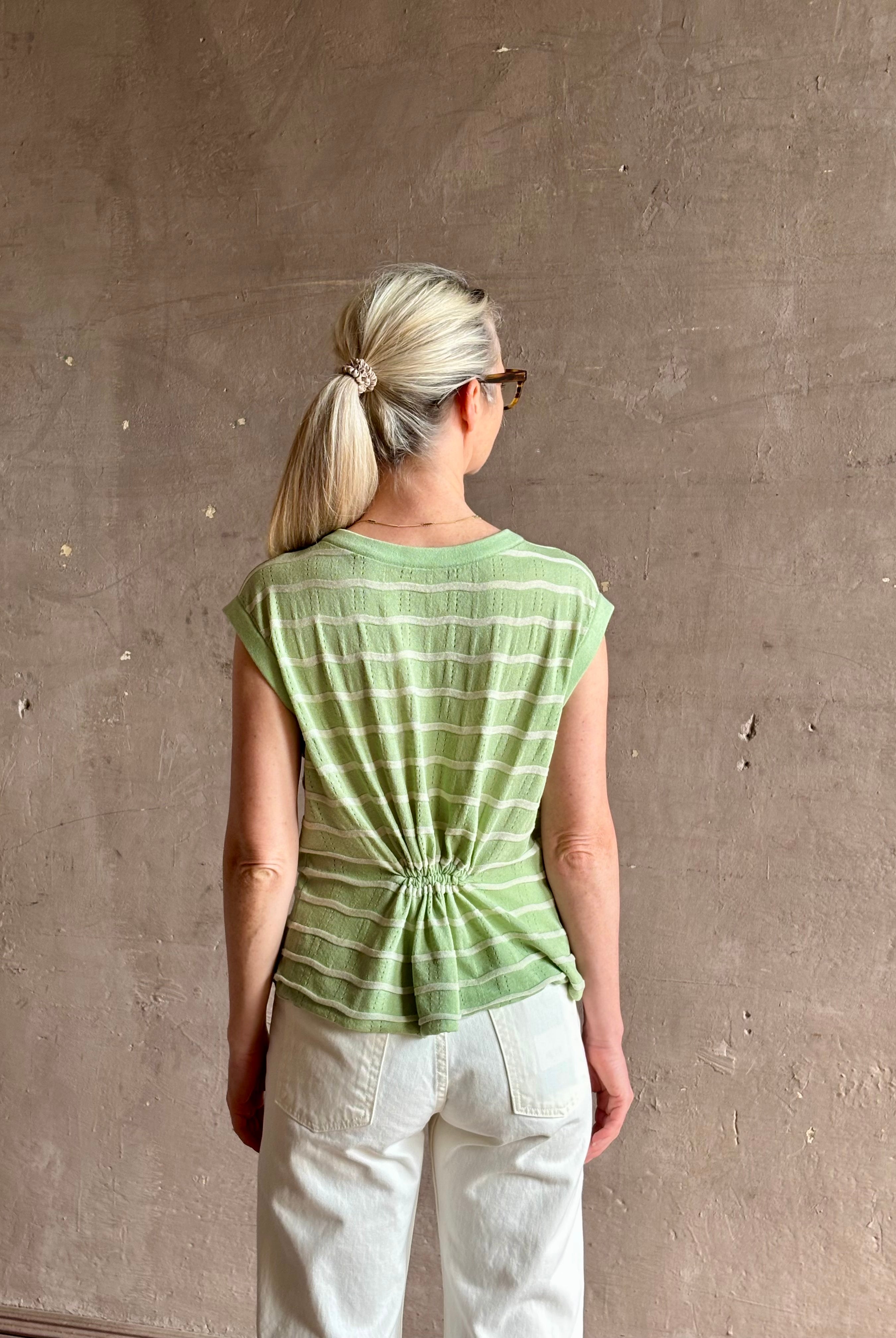 Mature woman wearing light green white horizontally striped Rachel Comey top gathered twist waist detail reversable