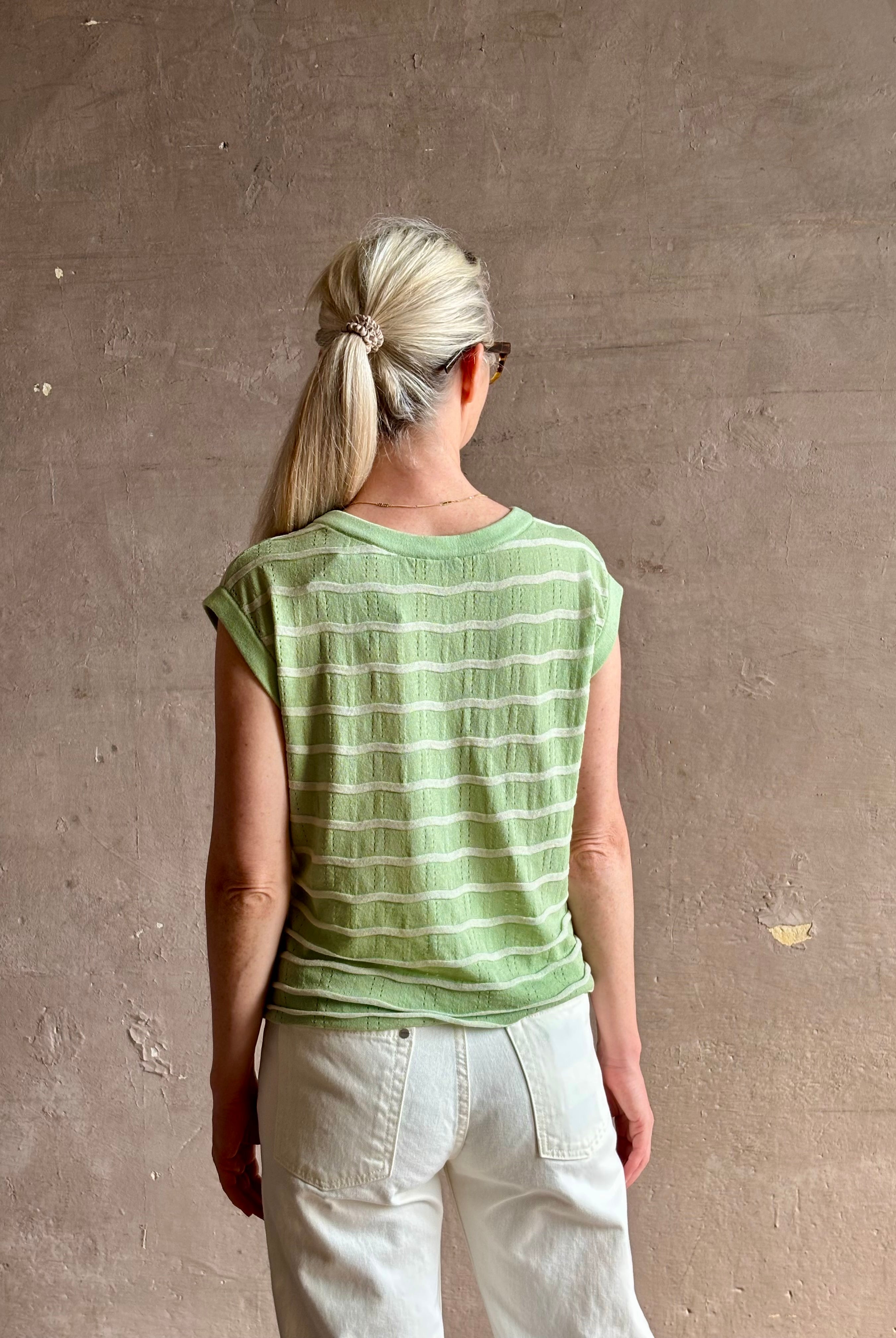 Mature woman wearing light green white horizontally striped Rachel Comey top gathered twist waist detail reversable