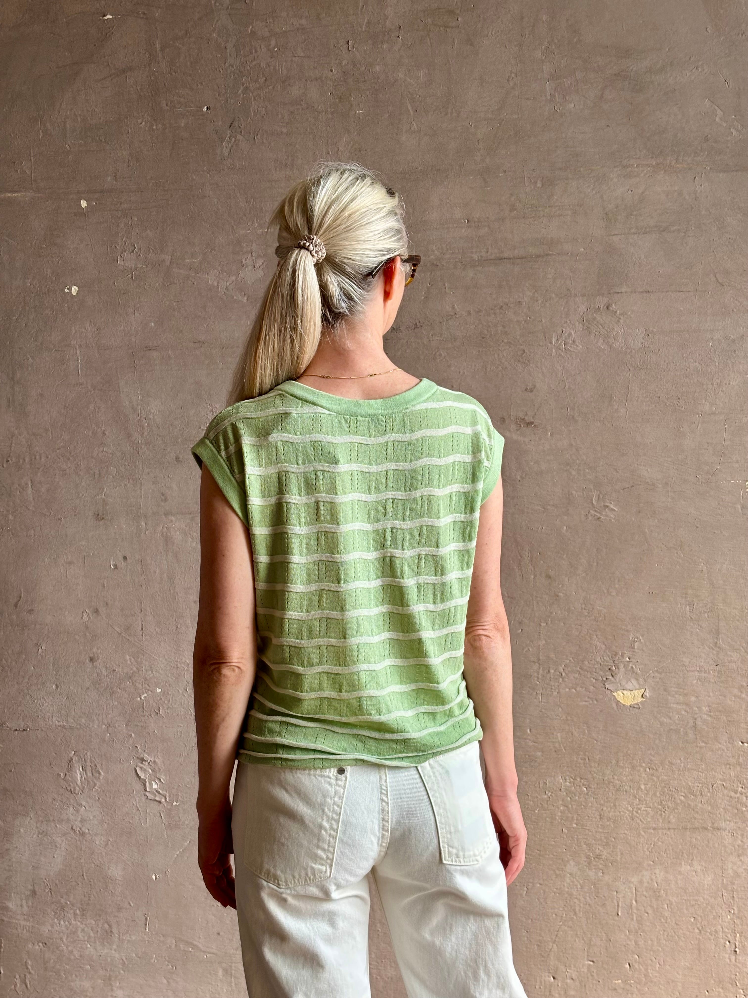 Mature woman wearing light green white horizontally striped Rachel Comey top gathered twist waist detail reversable