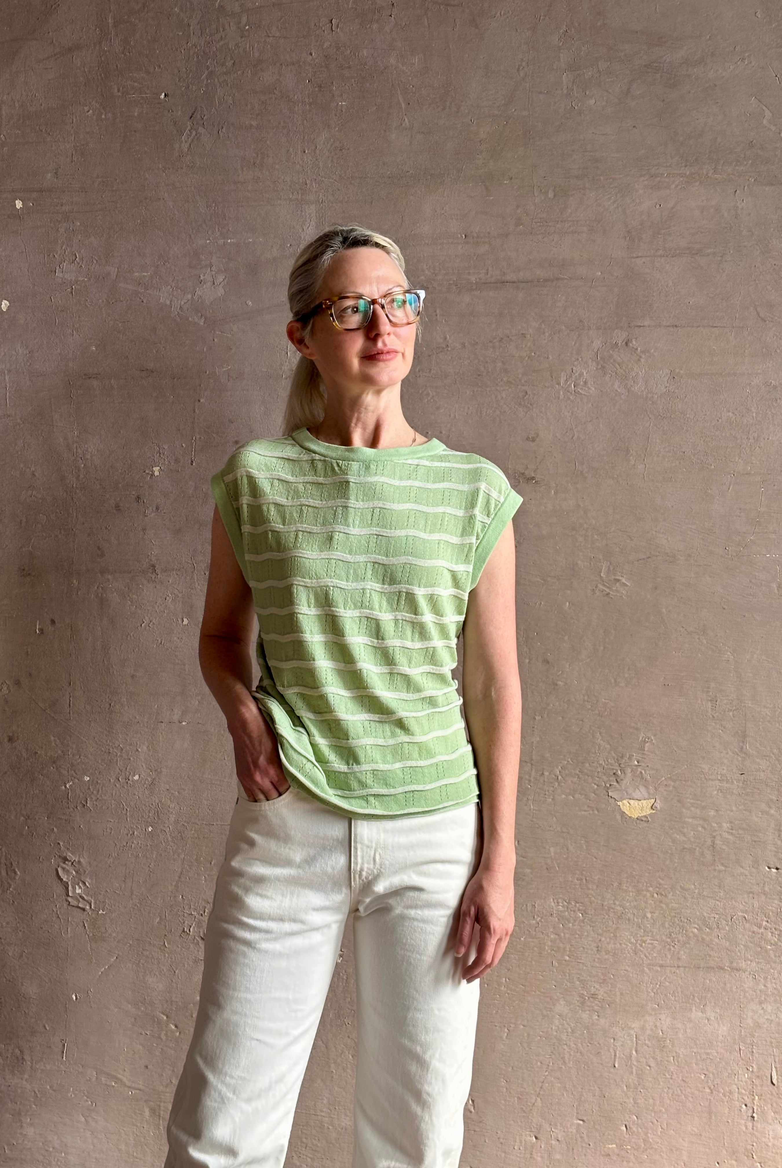 Mature woman wearing light green white horizontally striped Rachel Comey top gathered twist waist detail reversable