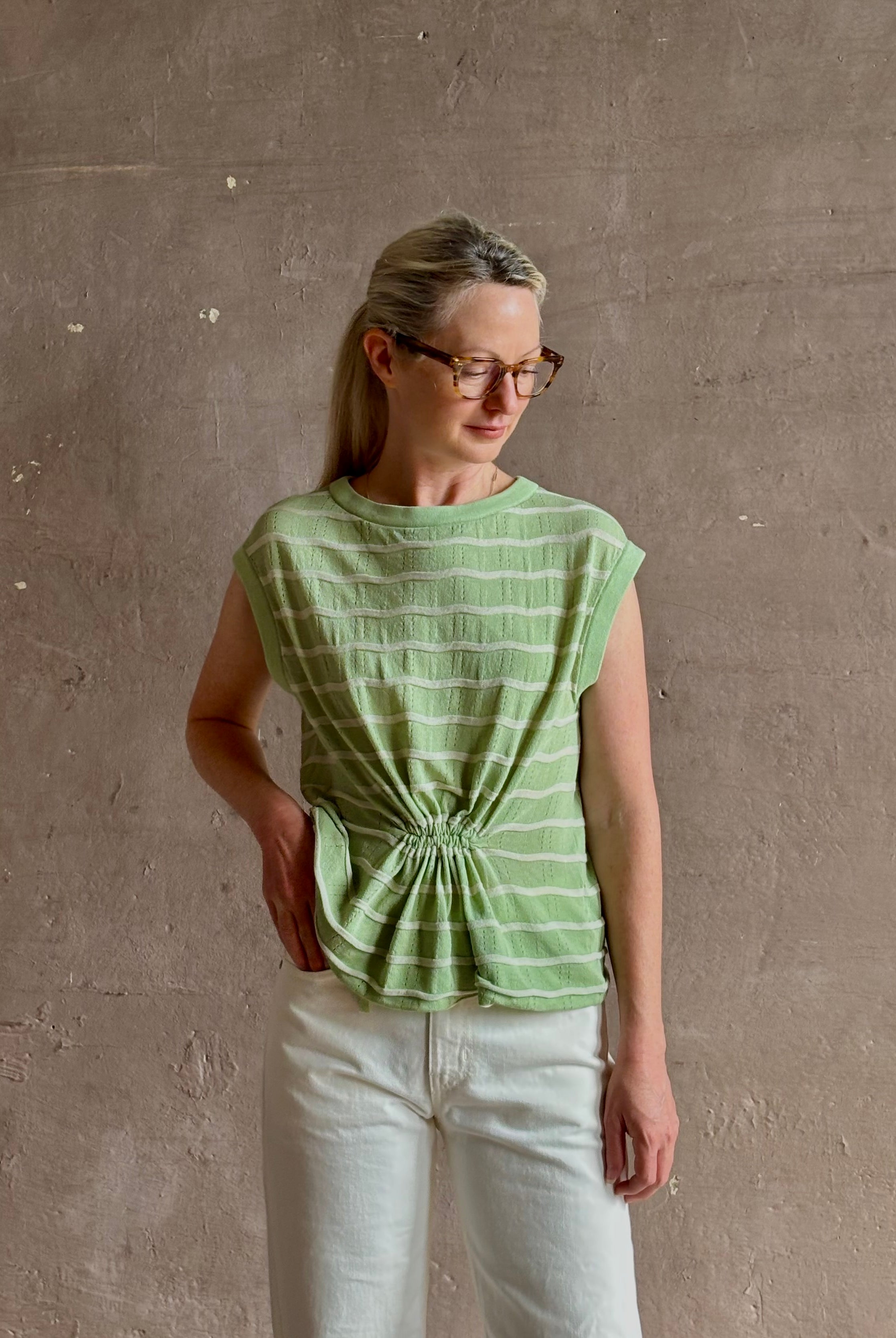 Mature woman wearing light green white horizontally striped Rachel Comey top gathered twist waist detail reversable
