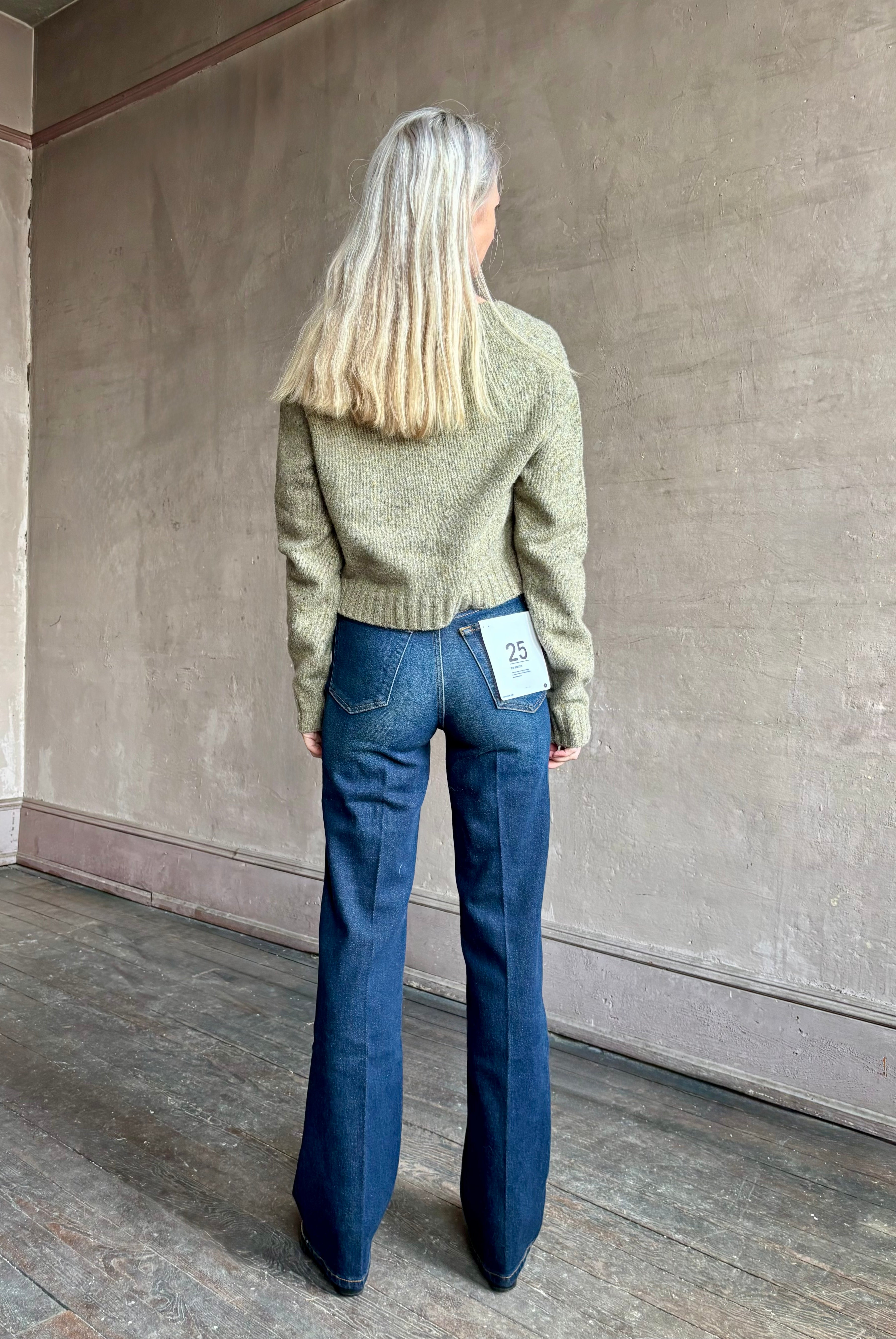 Woman wearing REDONE 70s Bootcut Denim in a dark blue wash with comfort stretch zip closure finished hem and 10.75" rise