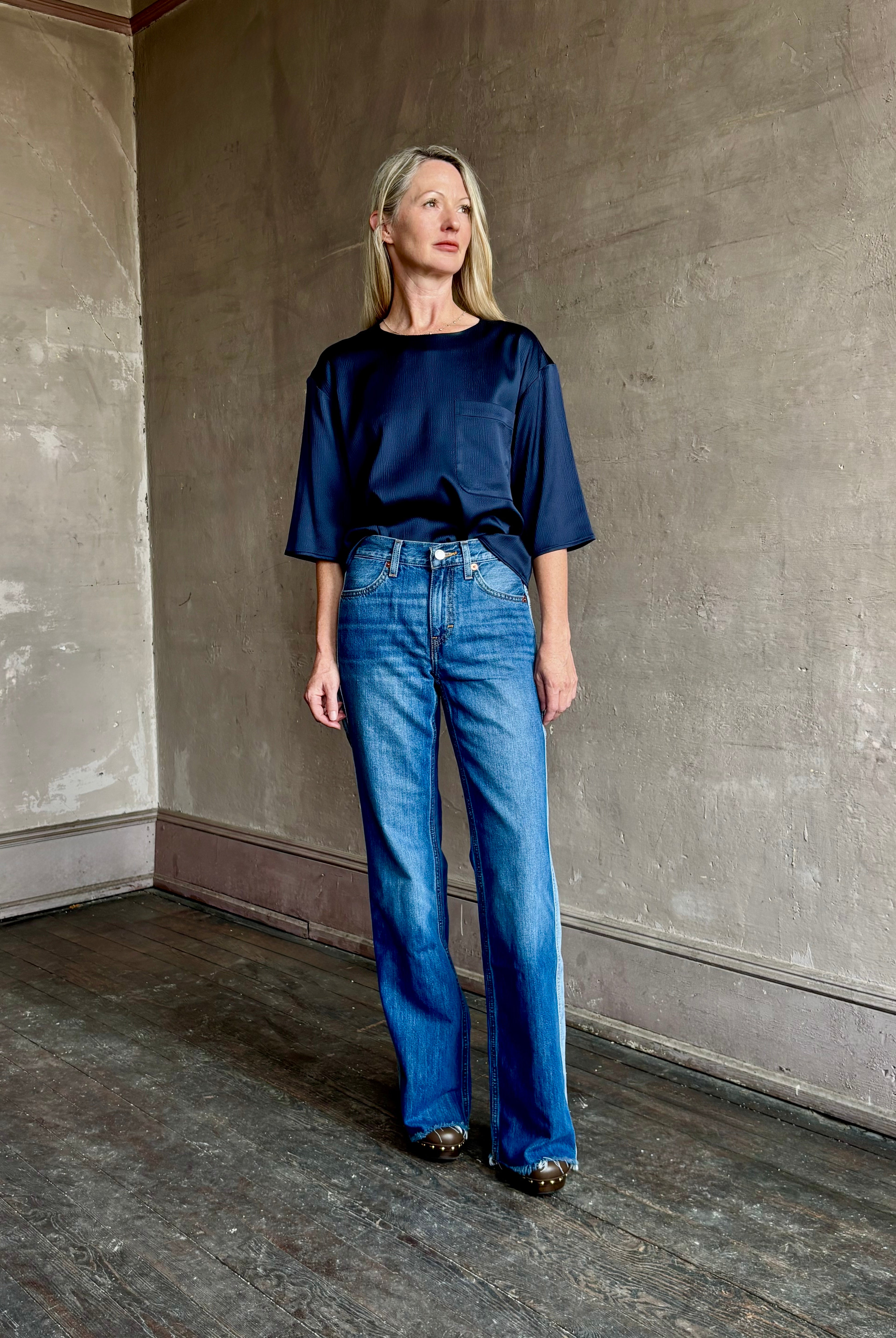 Image of mature woman wearing mid-rise jean ReDone track Californian denim with light blue stripe down side in Viper blue wash