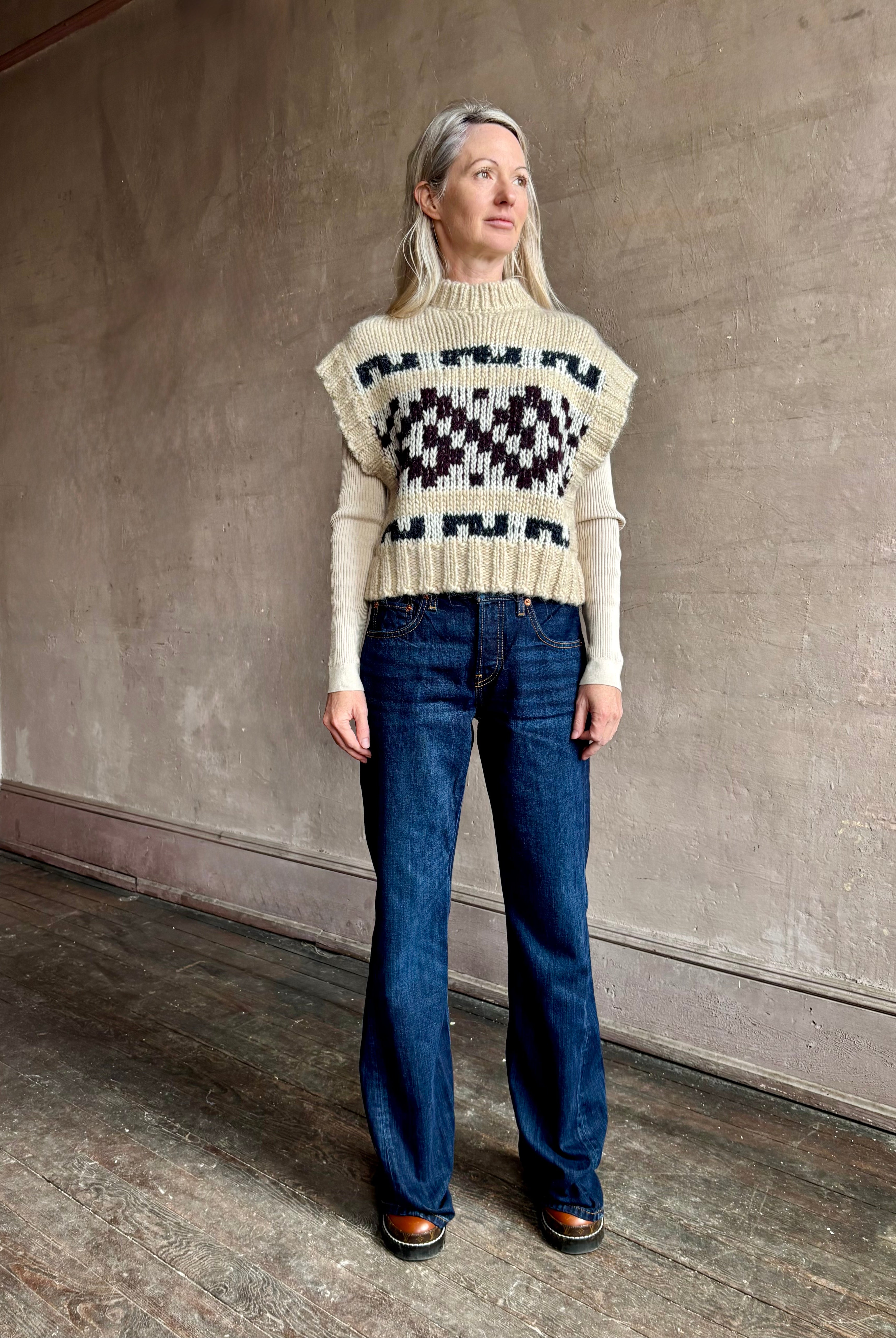 Woman wearing REDONE Twisted Mid Rise Bootcut Denim in a clean dark blue wash with a 9.5" rise and finished hem