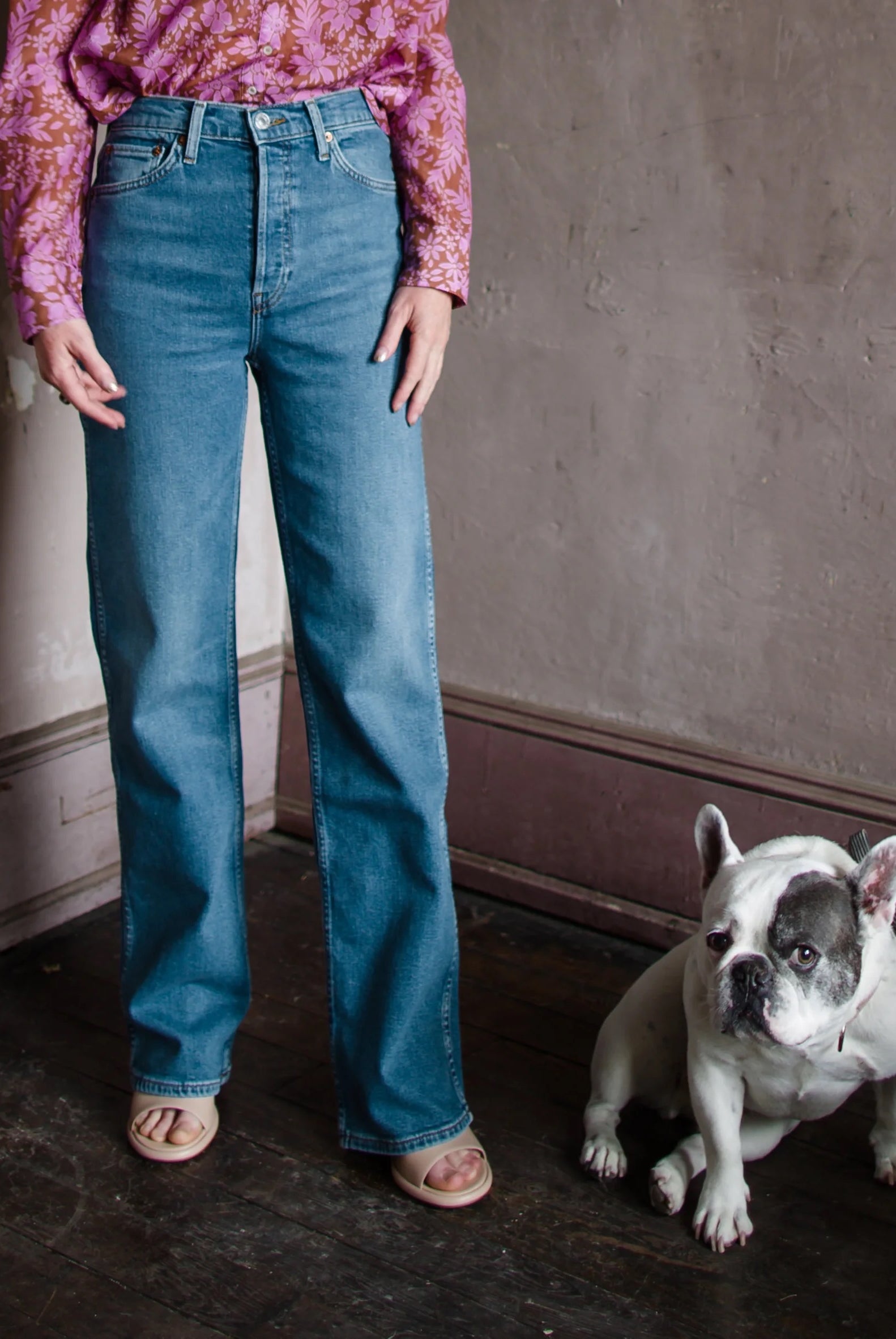 Mature woman wearing Re/Done 90s High Rise Loose aged indigo wash in stretch denim with button fly and finished hem