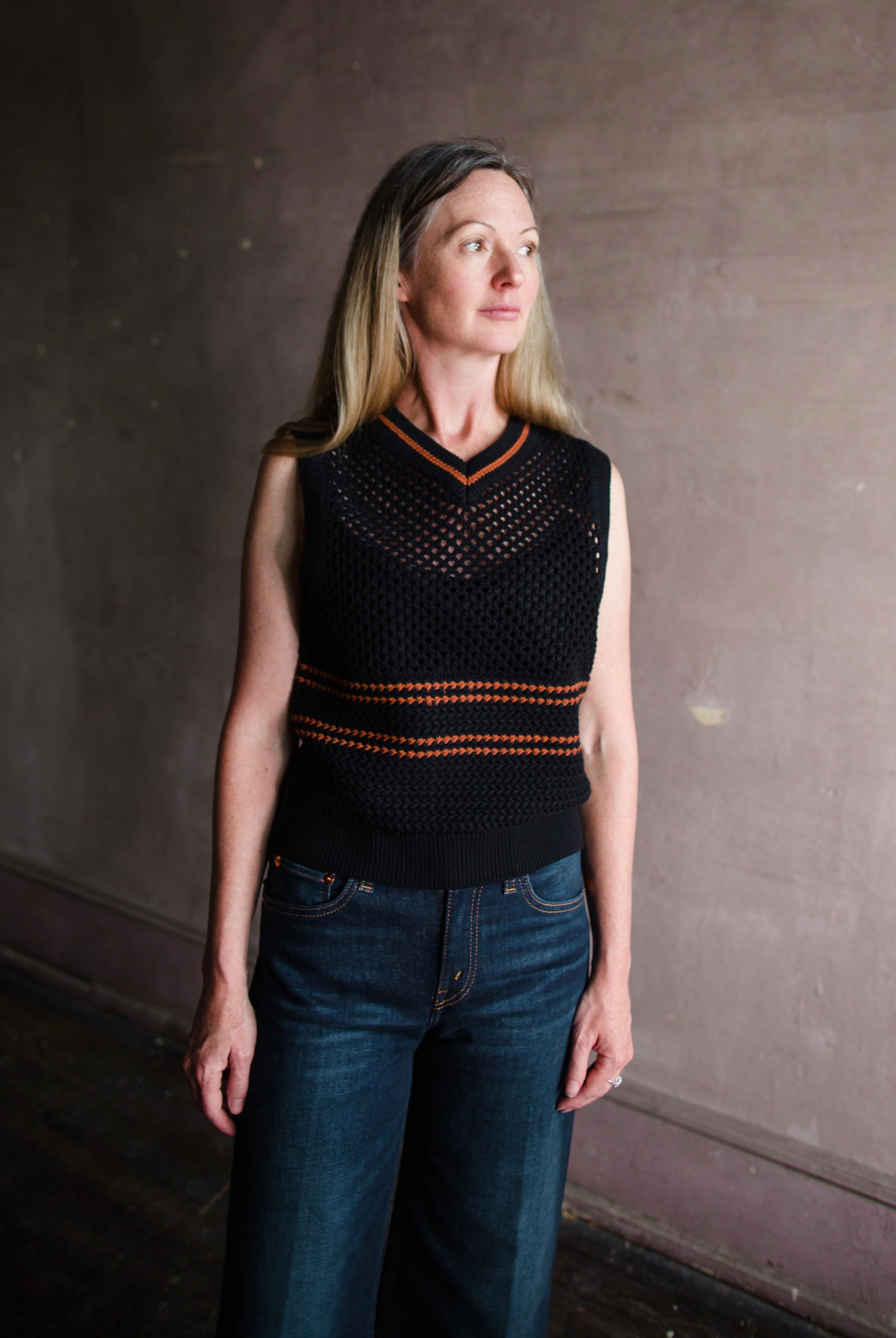 Mature woman wearing designer Re/Done black and brown stripe Crochet cotton Knit v-neck top made in USA
