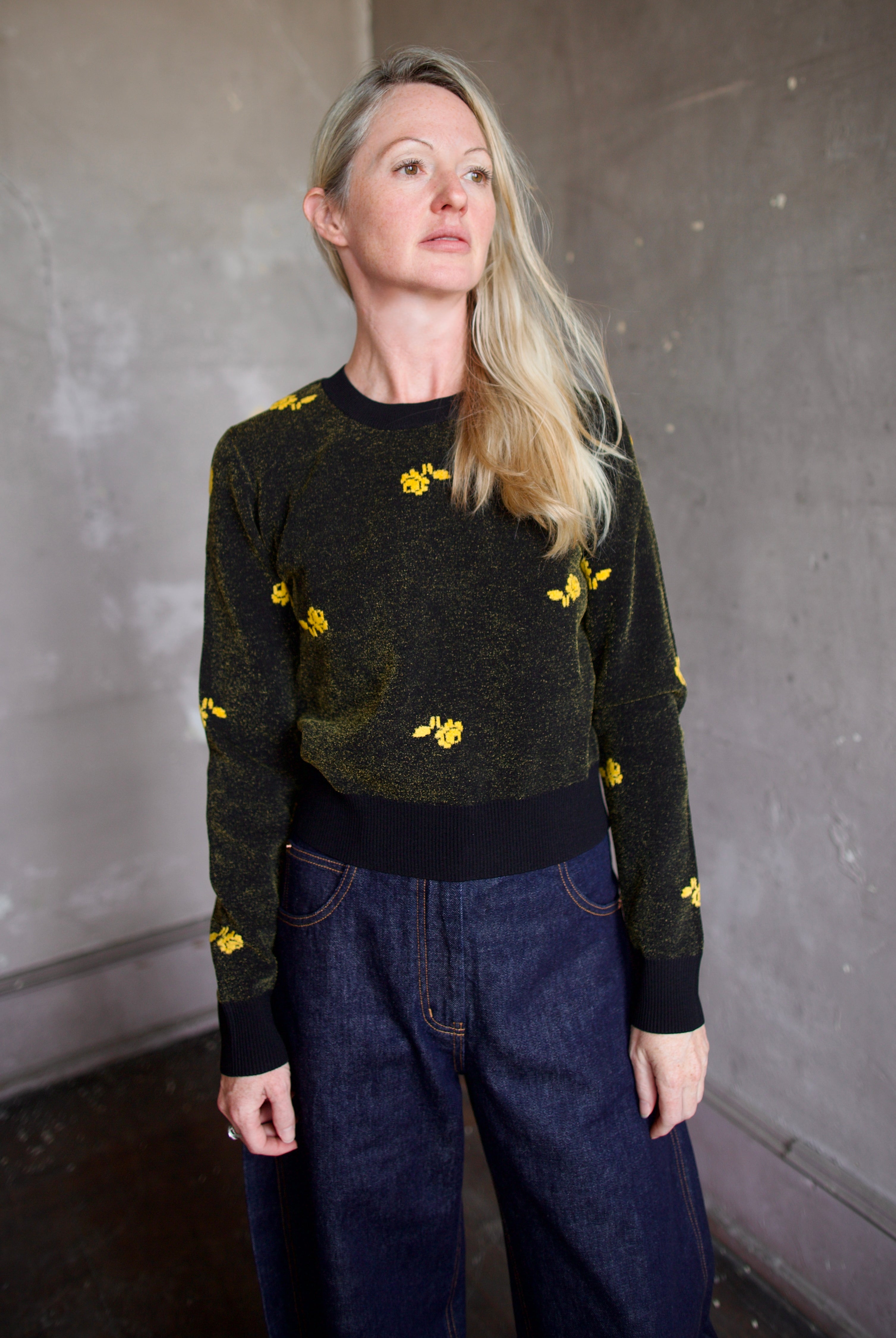 Model wearing a black Rachel Comey sweater with yellow floral patterns