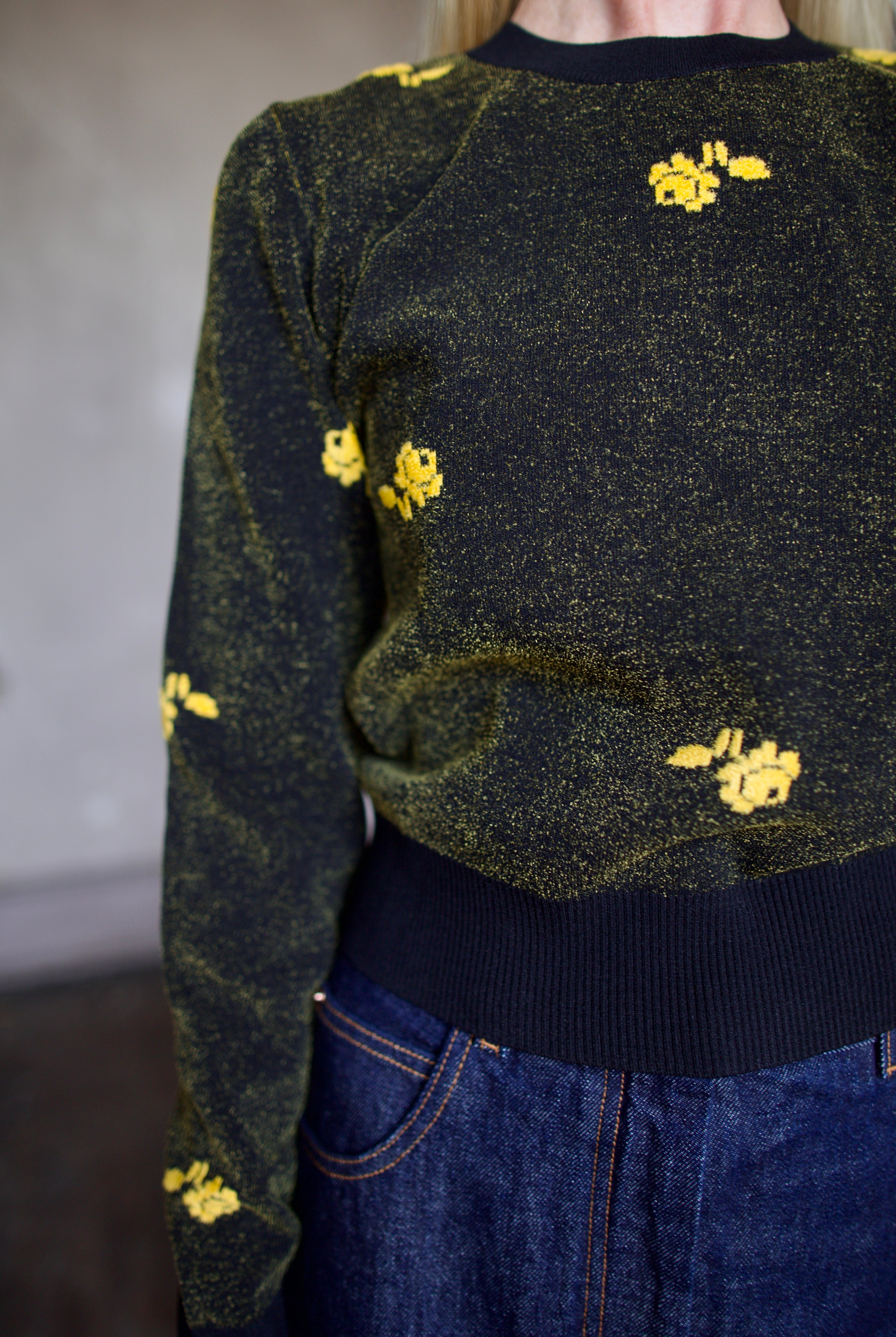 Model wearing a black Rachel Comey sweater with yellow floral patterns