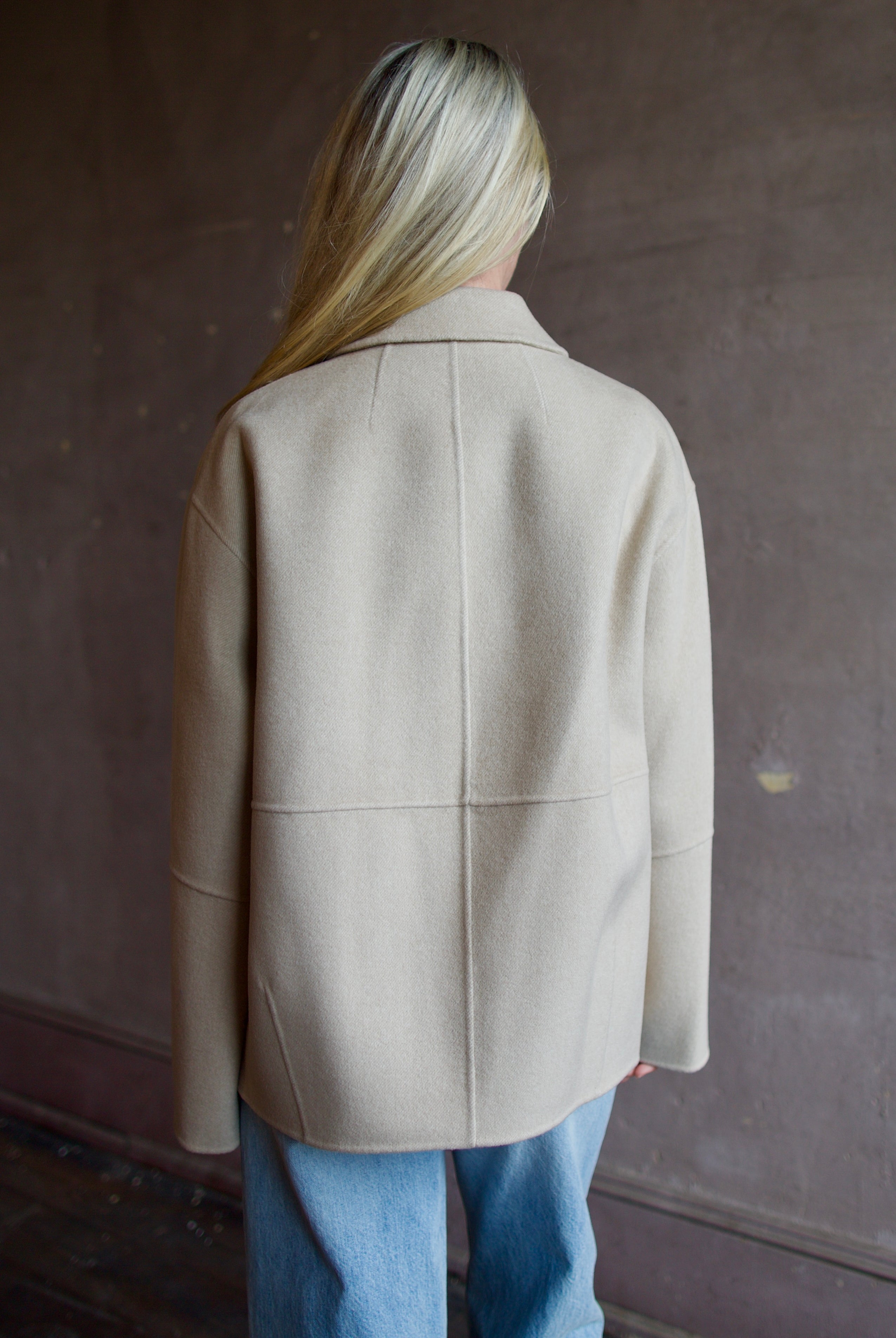 Model wearing a timeless beige cashmere coat by Rachel Comey