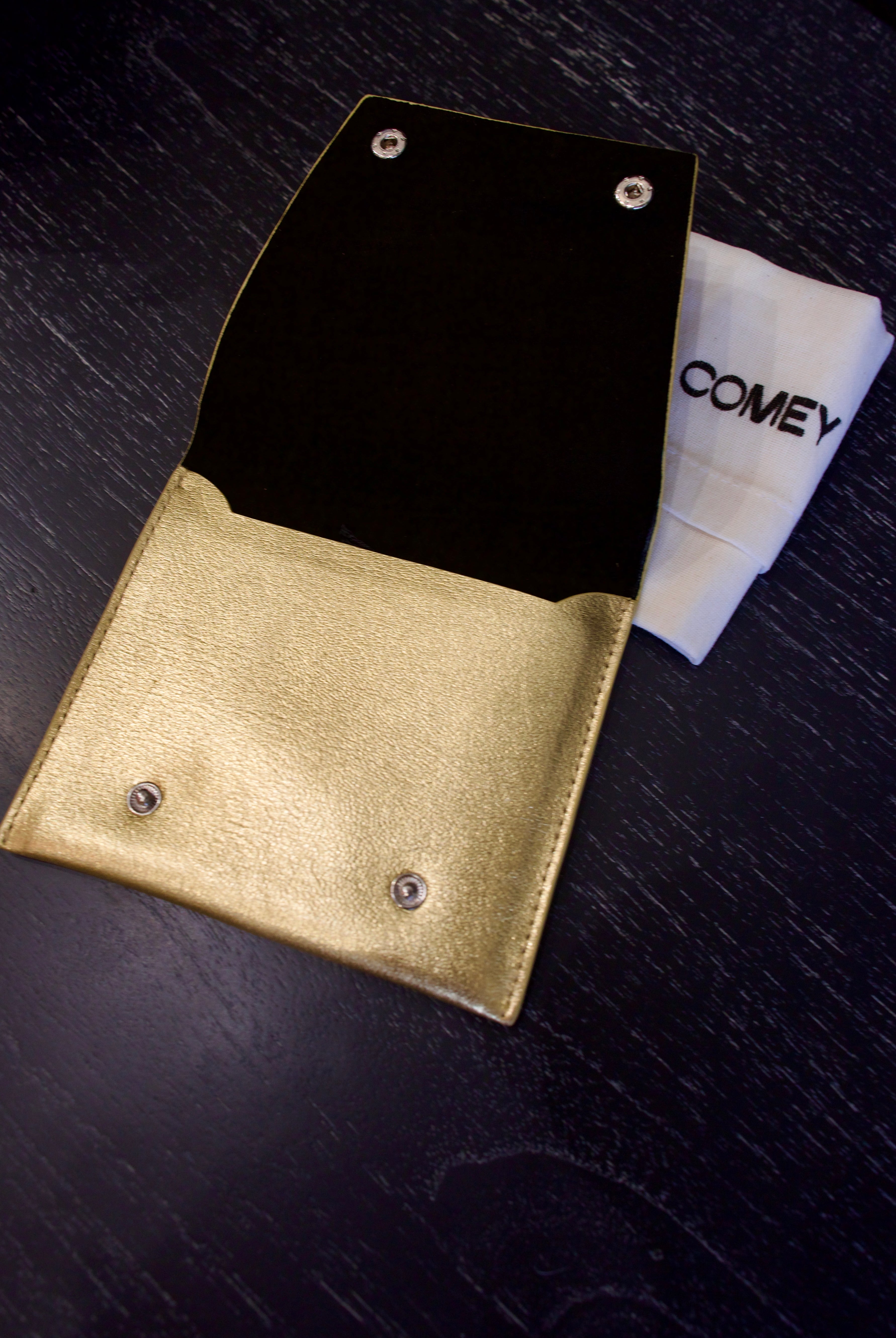 Open metallic gold Rachel Comey leather wallet with two snap buttons closure