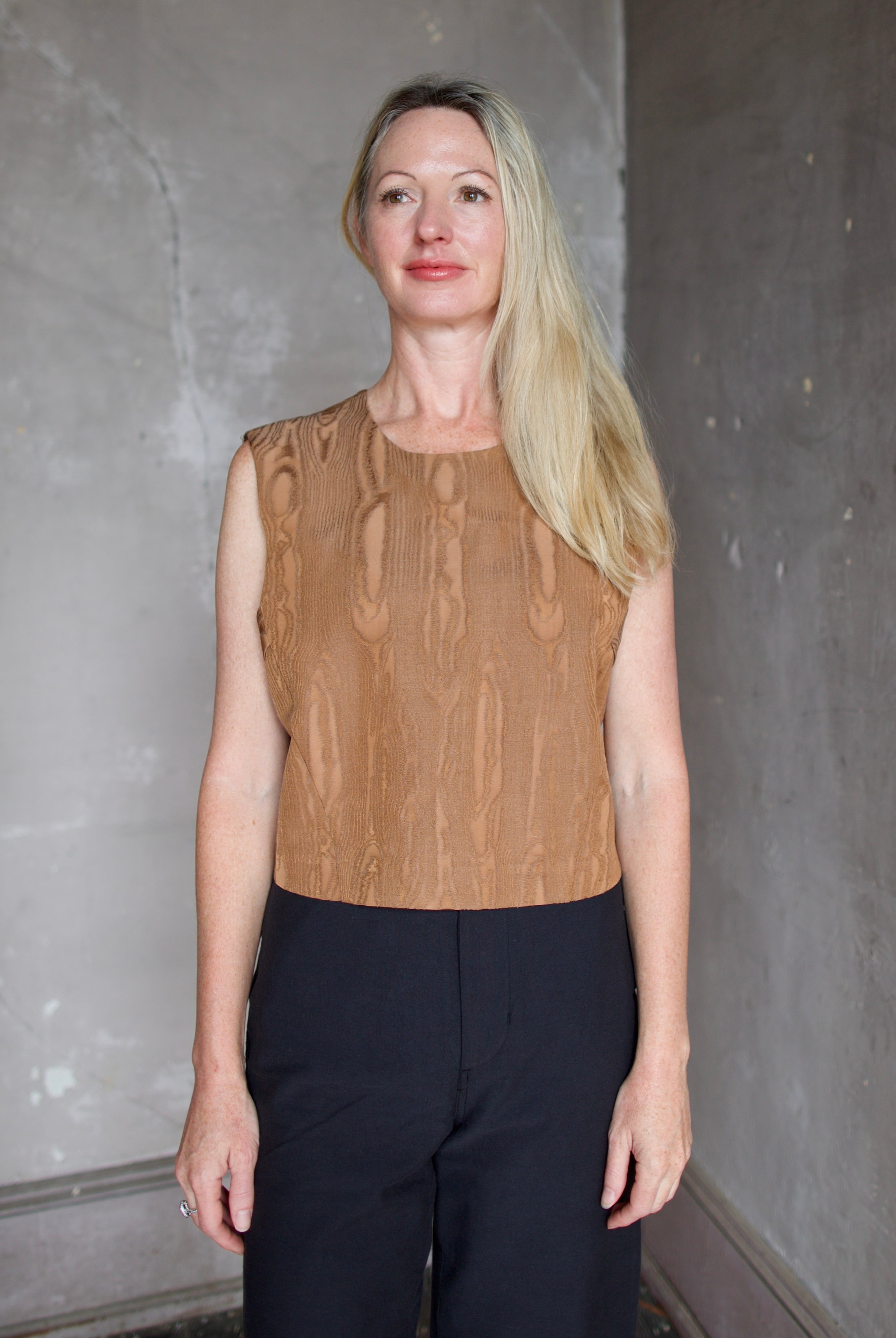 Model wearing a brown faux boise patterned top by designer Rachel Comey layered over a button down