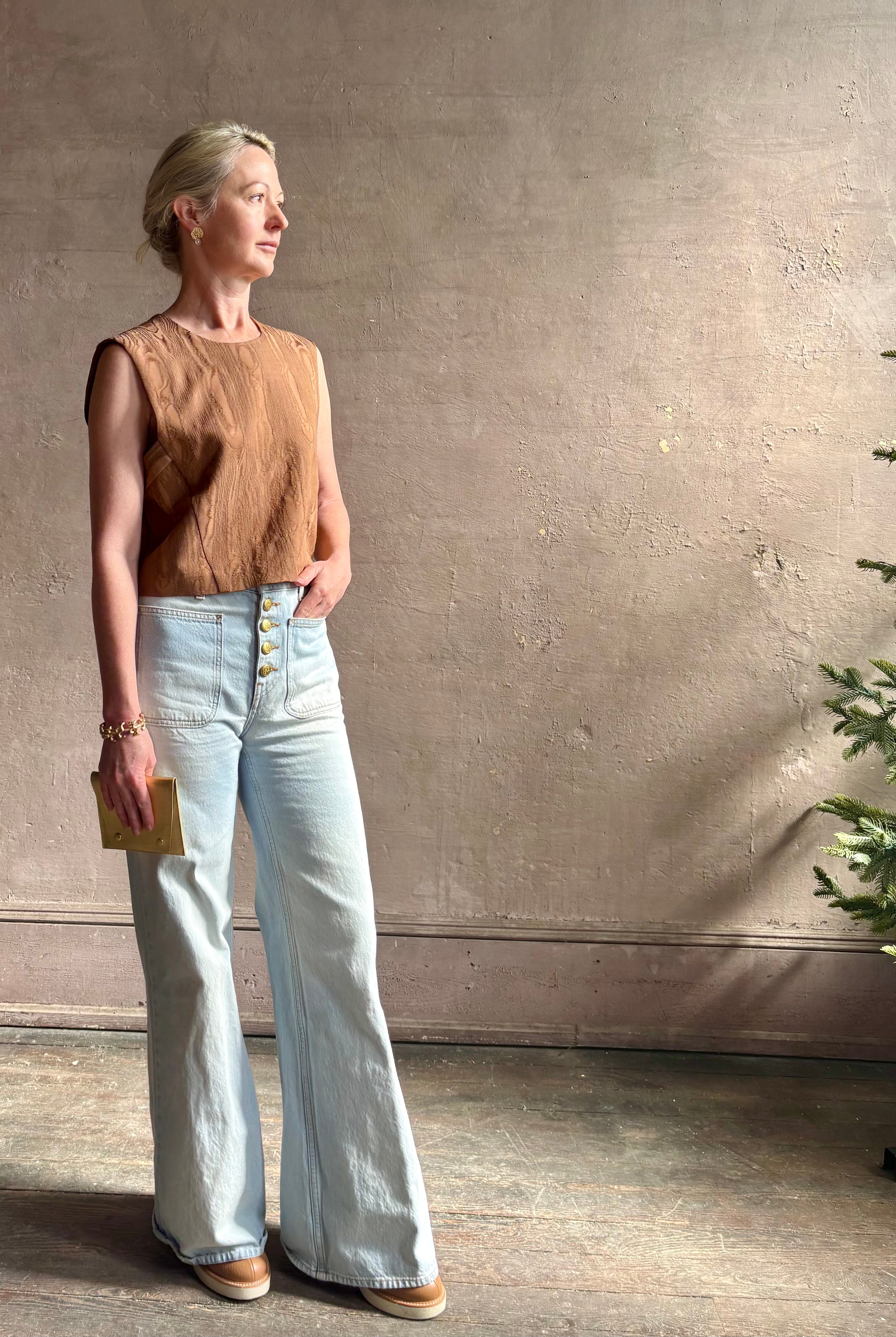 Mature woman wearing a brown faux boise patterned sleeveless viscose top by designer Rachel Comey with a crew neckline and button back closure