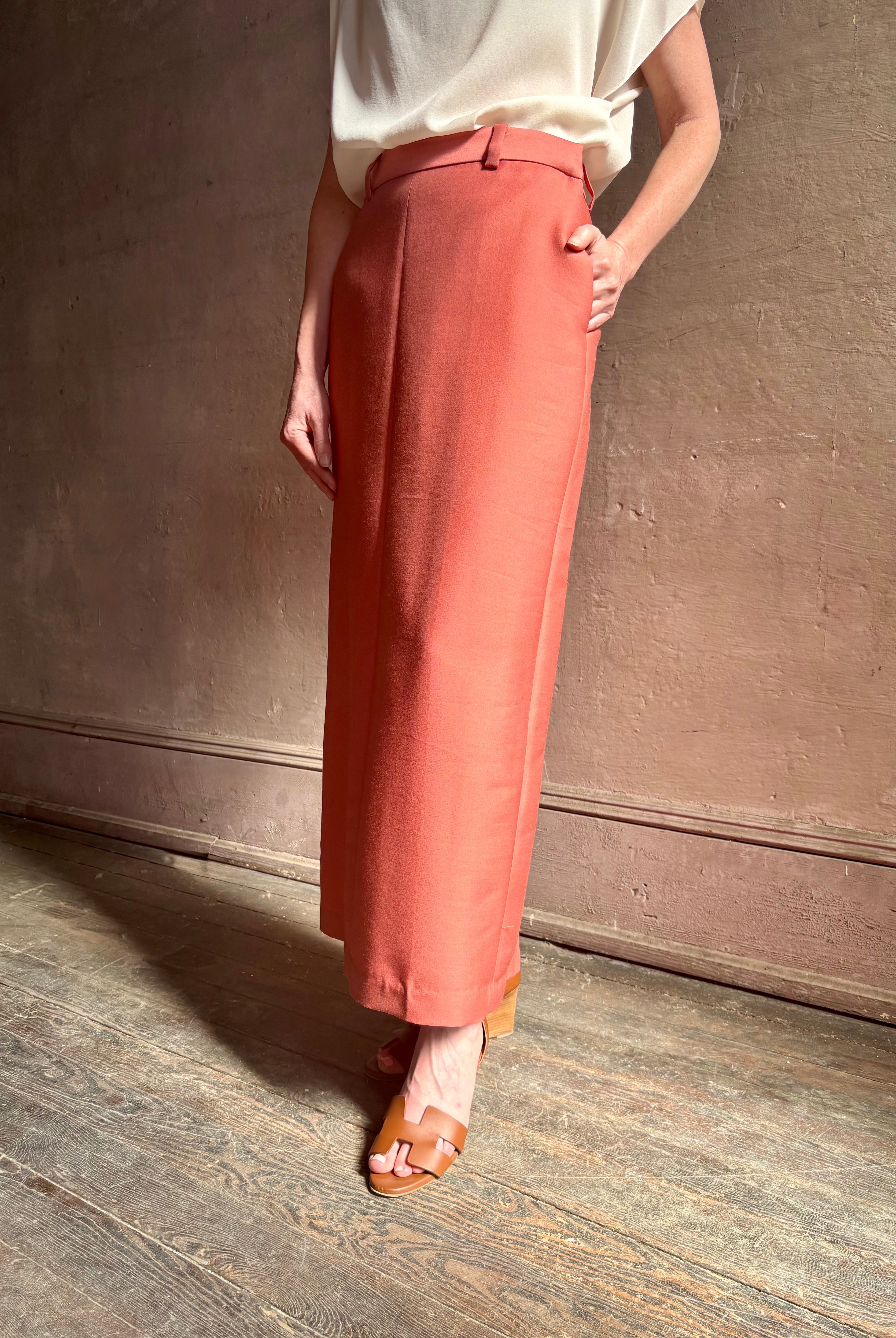 Mature woman wearing premium wool silk women's designer Rachel Comey Cosa maxi Skirt with tailored waistband, belt loops and back vent rendered in a vibrant warm pink hue