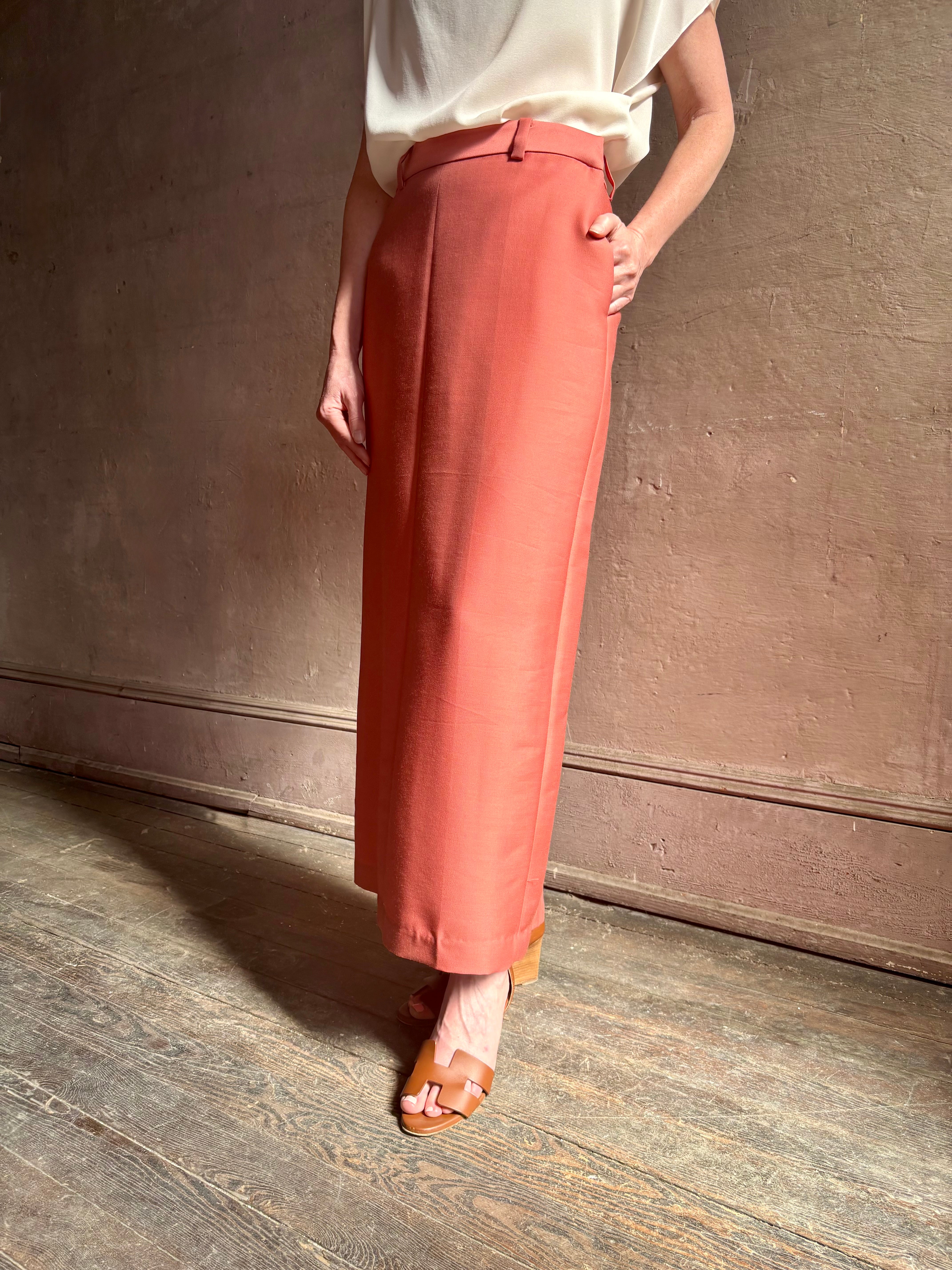 Mature woman wearing premium wool silk women's designer Rachel Comey Cosa maxi Skirt with tailored waistband, belt loops and back vent rendered in a vibrant warm pink hue