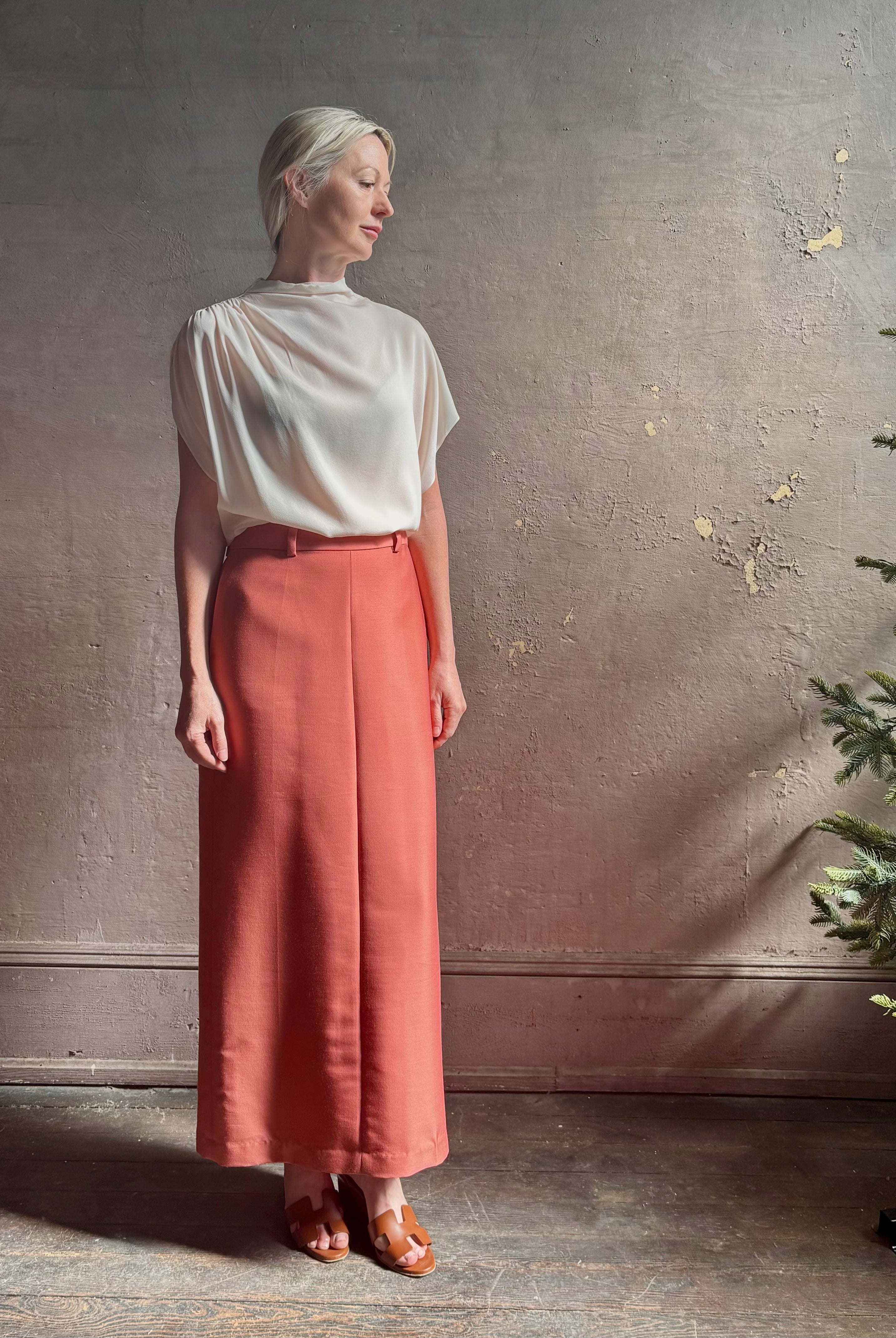 Mature woman wearing premium wool silk women's designer Rachel Comey Cosa maxi Skirt with tailored waistband, belt loops and back vent rendered in a vibrant warm pink hue
