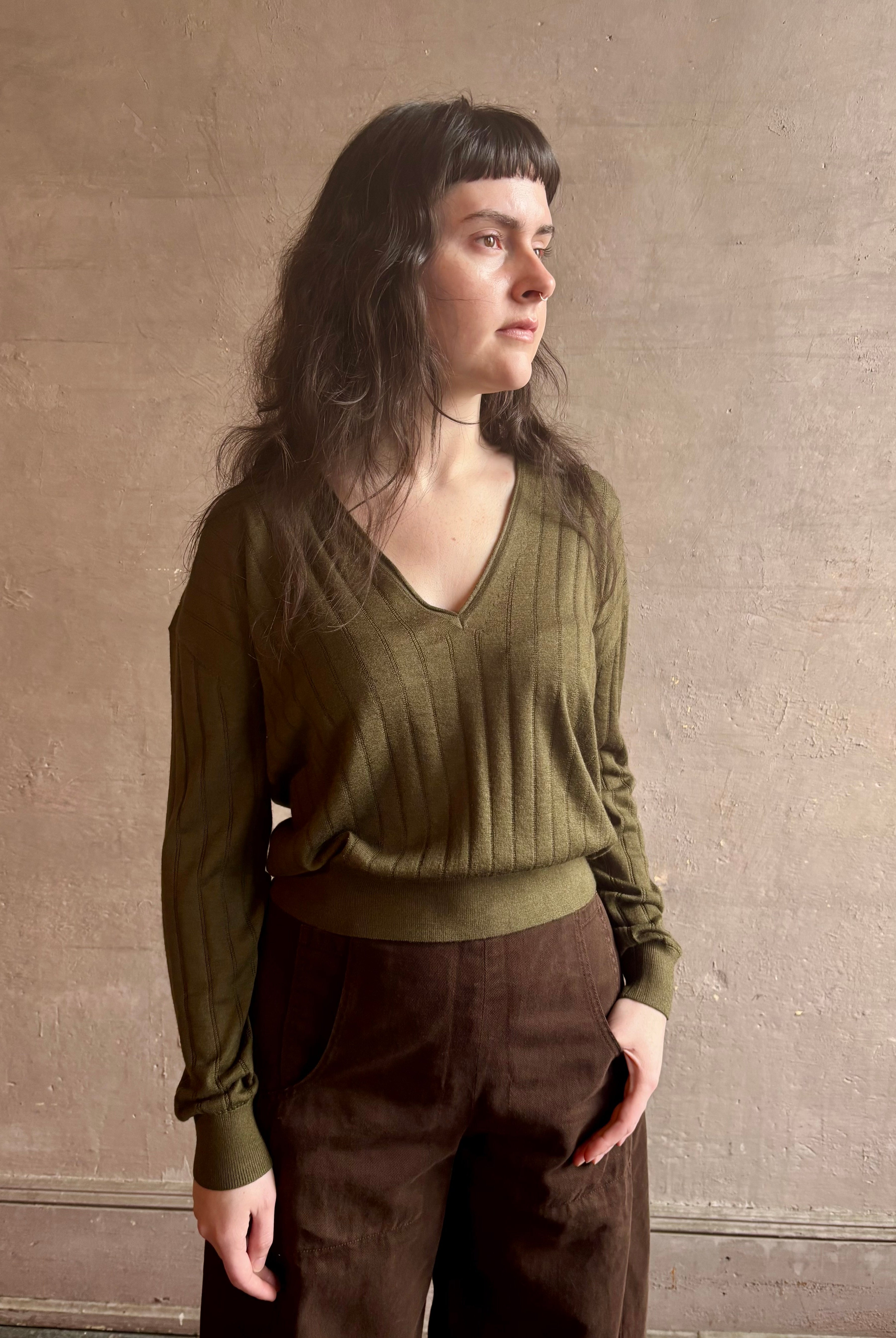 Image of woman wearing luxury Cashmere Silk Marion V-Neck designer Sweater by Rachel Comey in olive green with long sleeves and linear weave