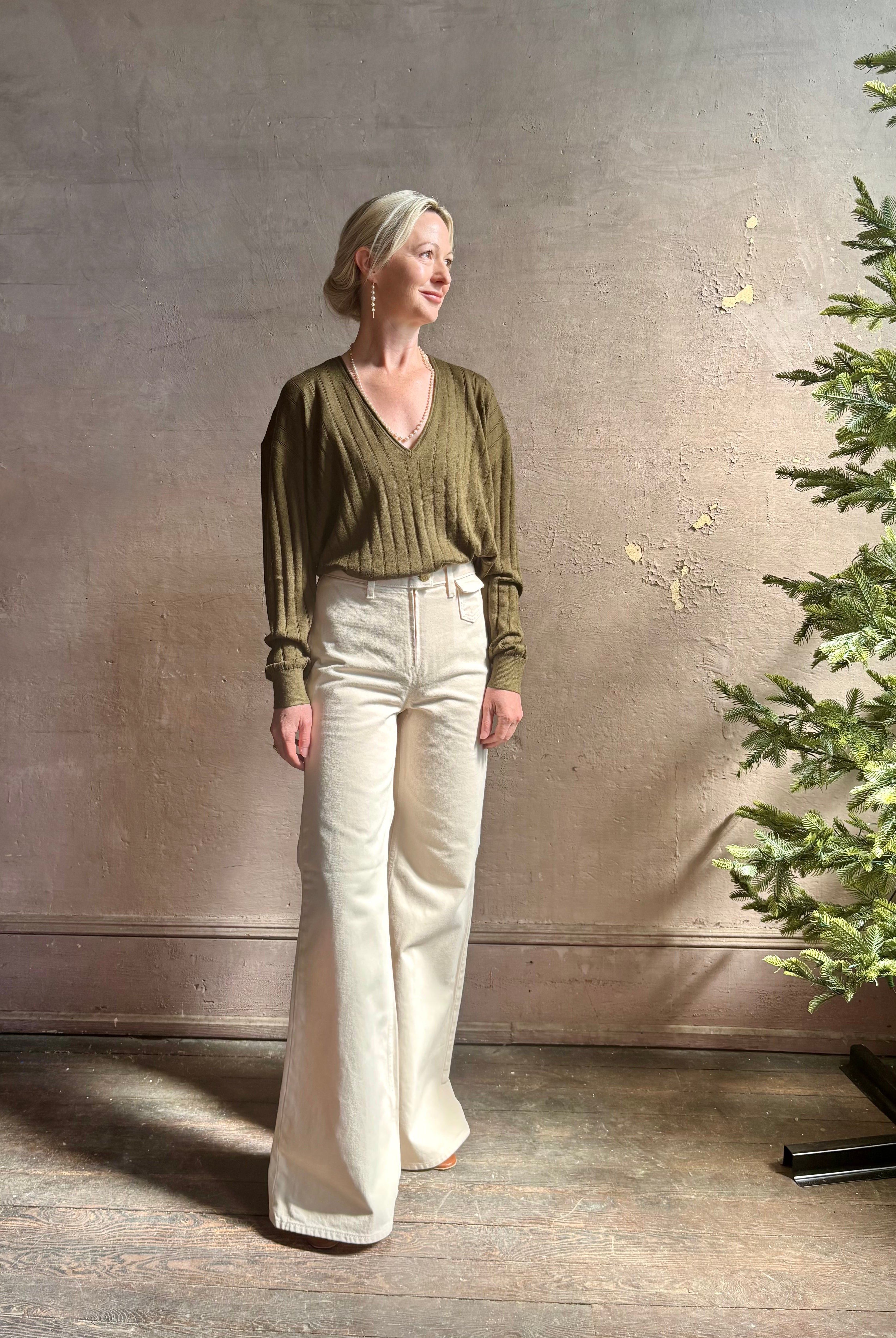 Mature woman wearing luxury Cashmere Silk Marion V-Neck designer Sweater by Rachel Comey in olive green with long sleeves and linear weave