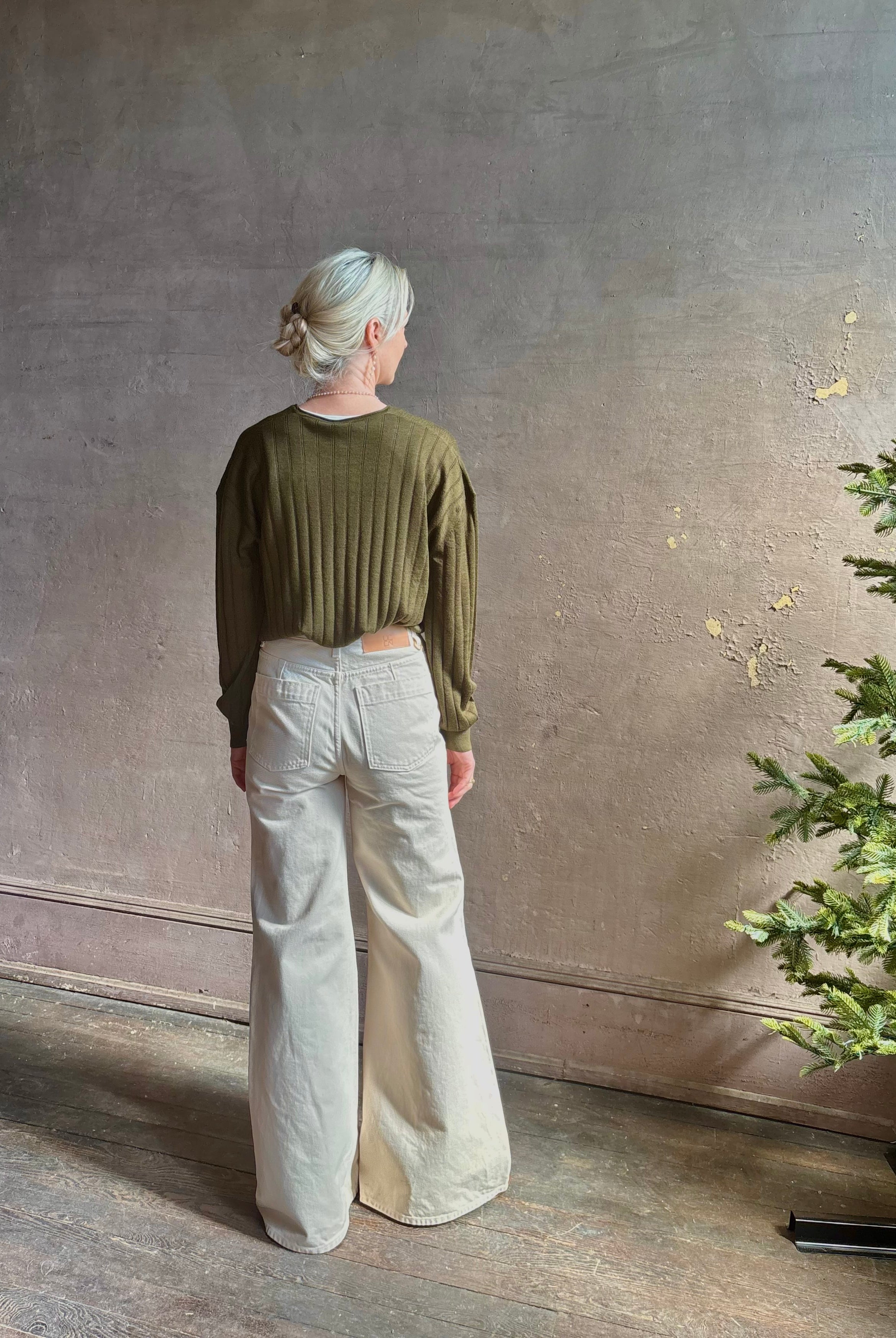 Mature woman wearing luxury Cashmere Silk Marion V-Neck designer Sweater by Rachel Comey in olive green with long sleeves and linear weave