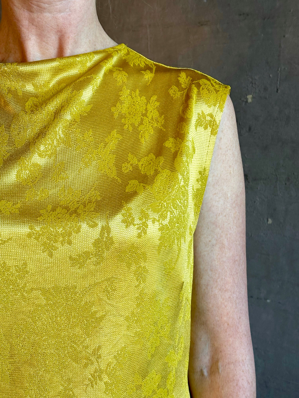 Mature woman wearing Rachel Comey Primula Pique Knit Top in Mustard yellow waterfall front tone-on-tone jacquard floral made in the USA