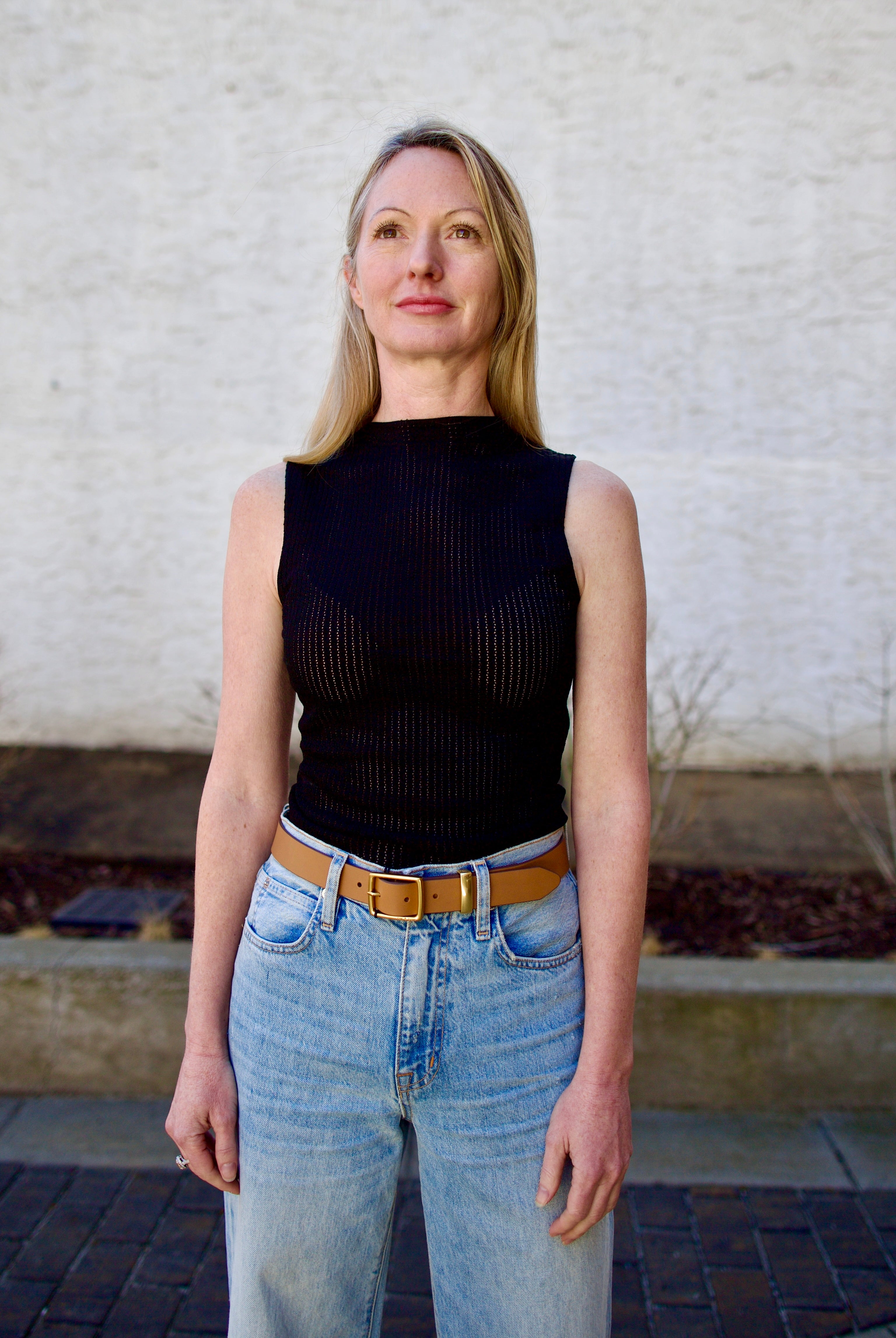 Woman wearing the Rag and Bone Molly Mock Neck black Top in semi-sheer knit construction and expertly designed minimalist silhouette
