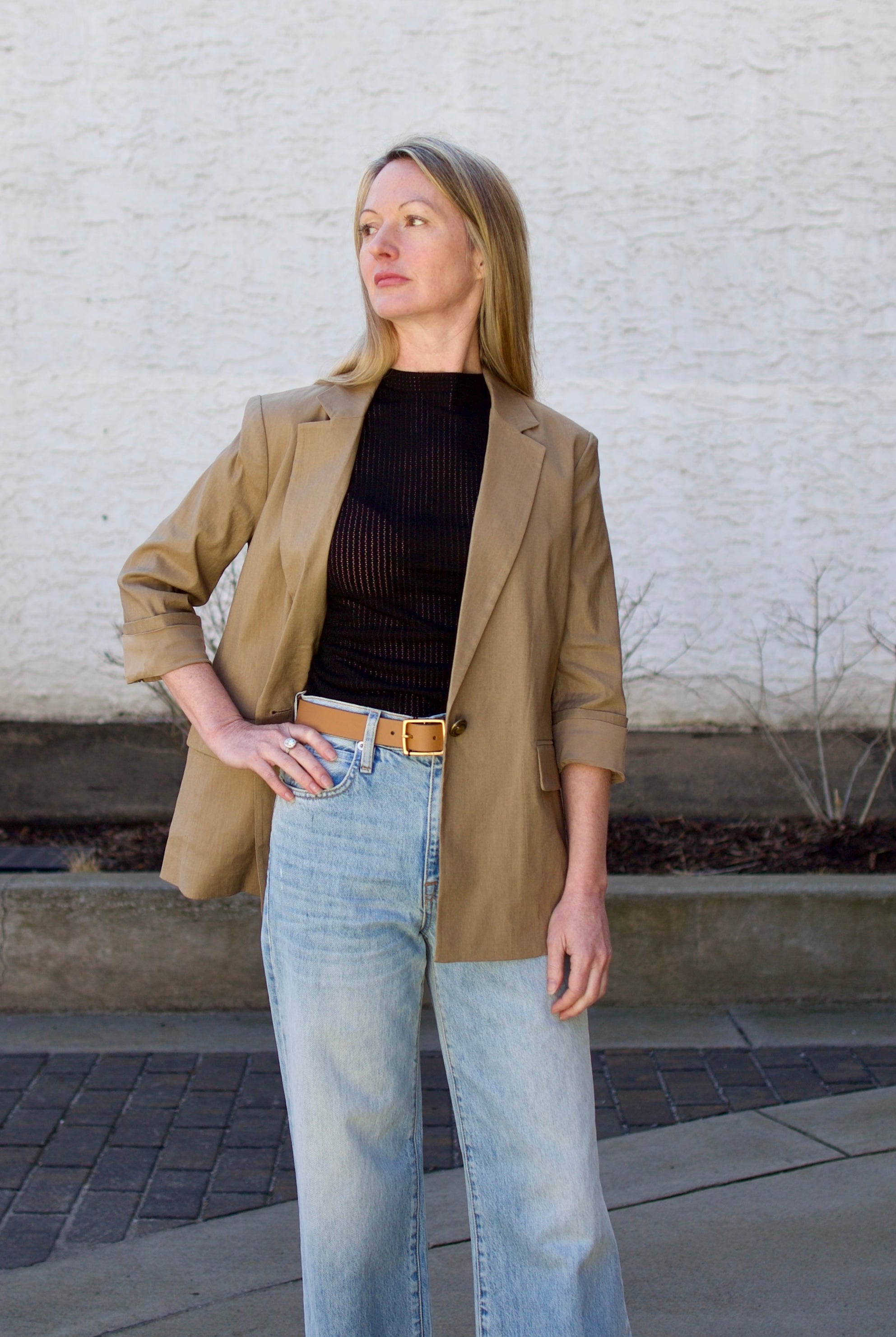 Woman wearing the Rag and Bone Molly Mock Neck black Top in semi-sheer knit construction and expertly designed minimalist silhouette
