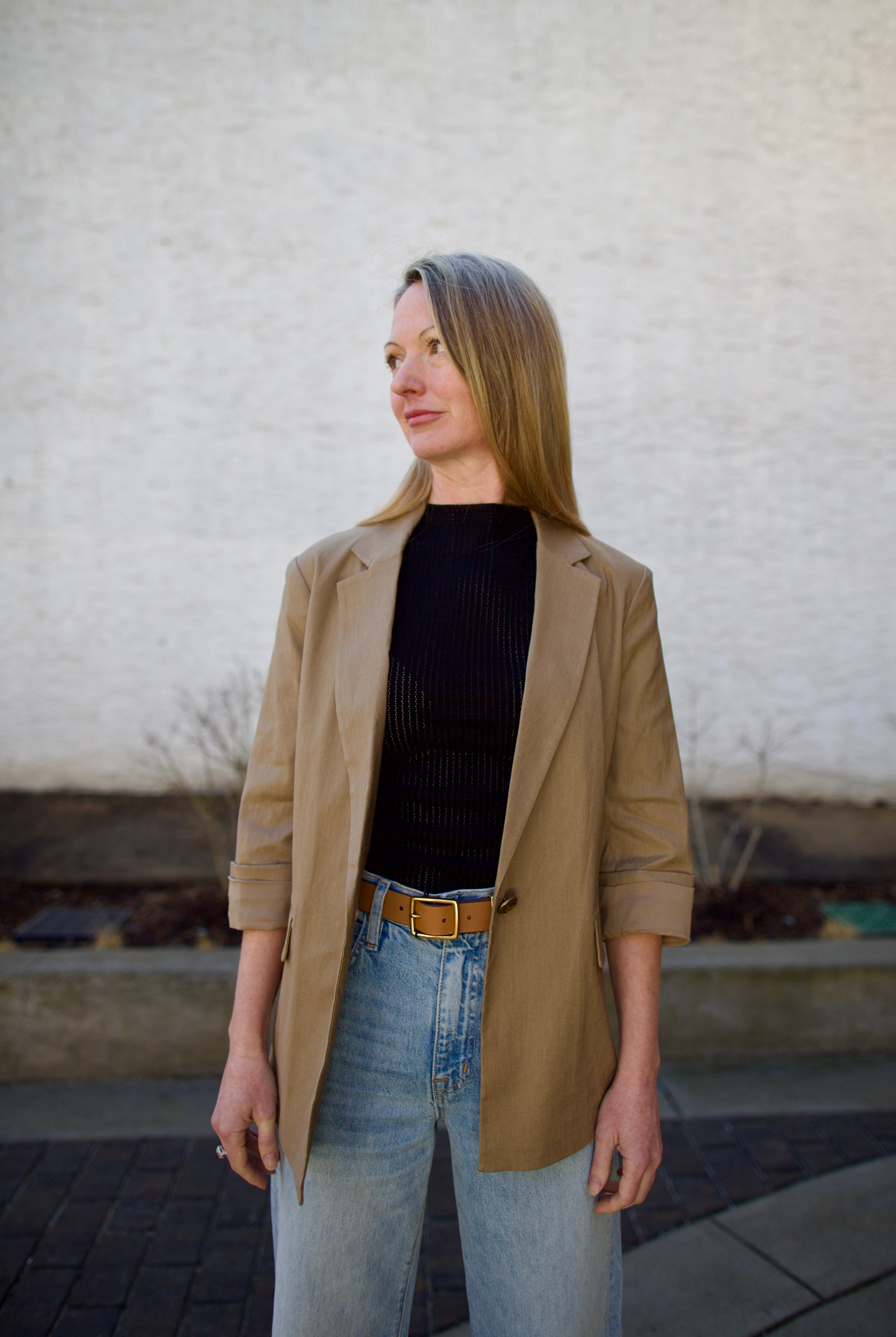Woman wearing the Rag and Bone Molly Mock Neck black Top in semi-sheer knit construction and expertly designed minimalist silhouette