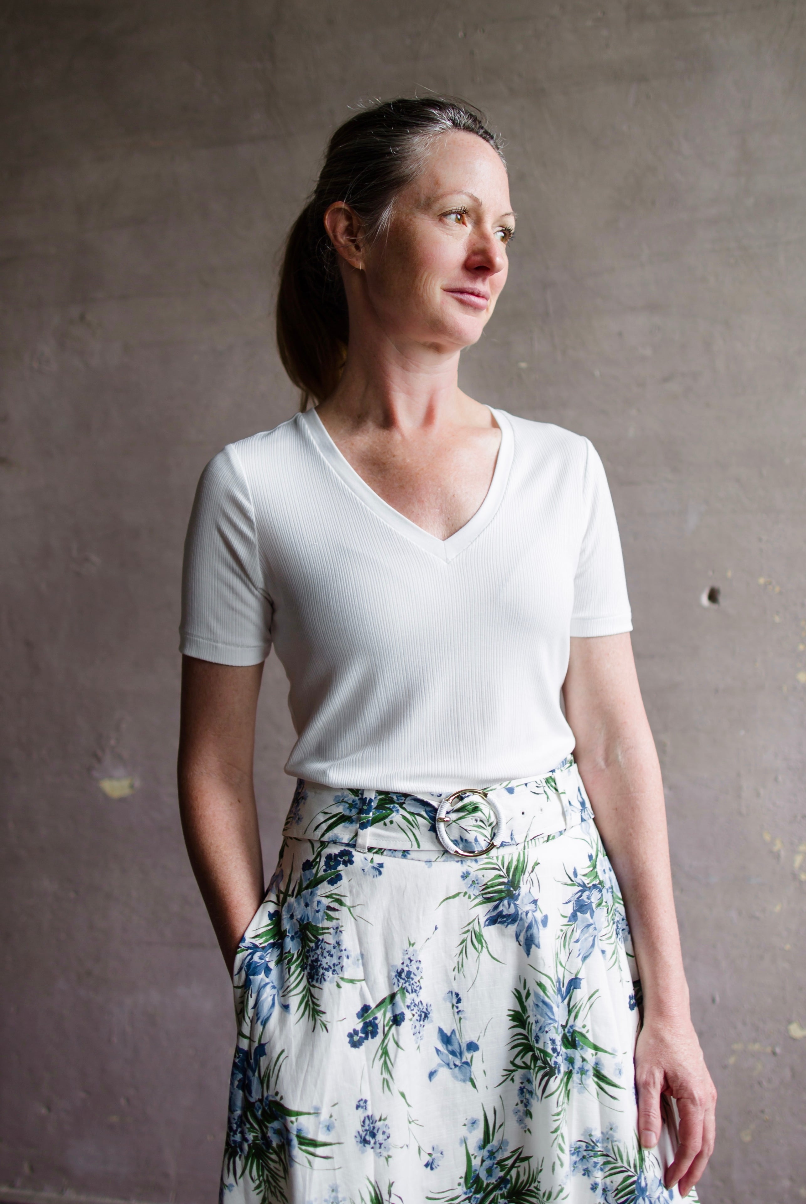 Image featuring a woman wearing the Rag & Bone Luca T-shirt with a rib-knit, V-neck and classic short sleeves in white.