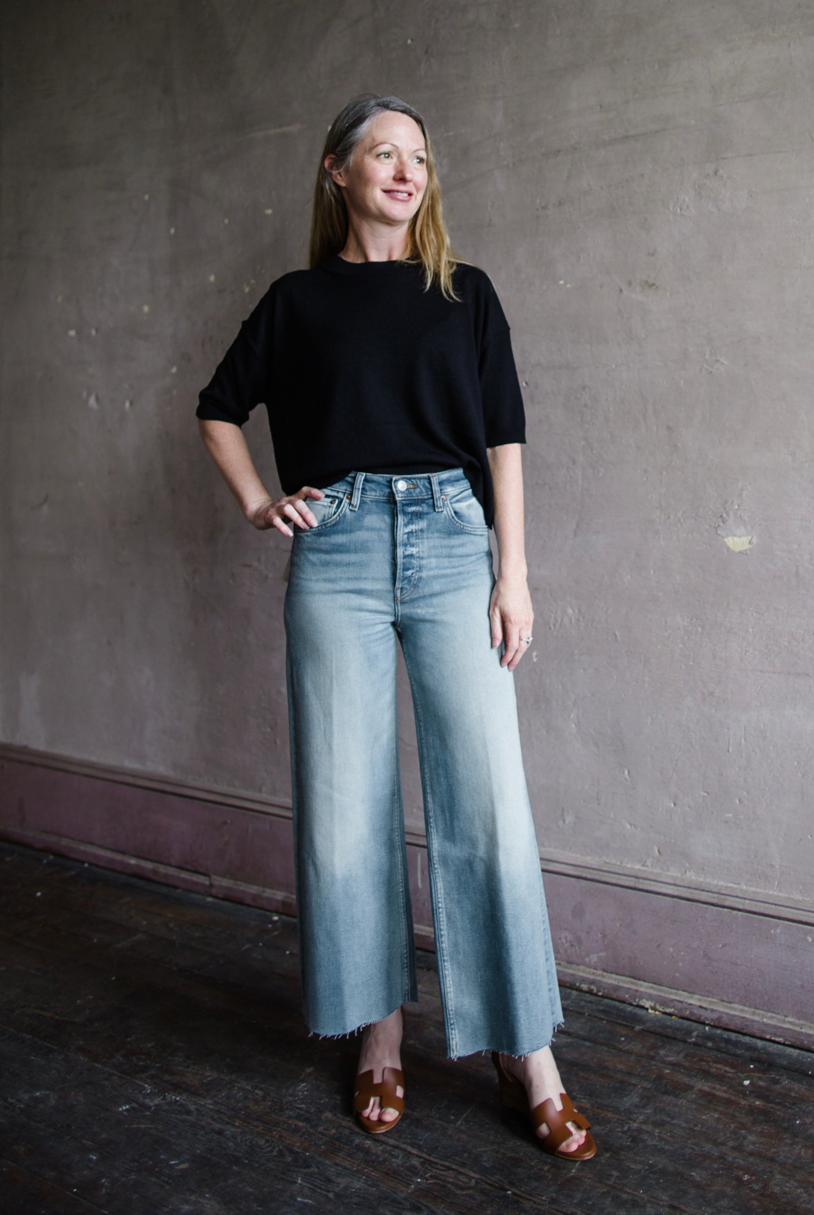 Image featuring a woman wearing the 100% cotton rigid jeans by Re/Done with a high rise, wide leg and cropped length in Bella Rosa wash.