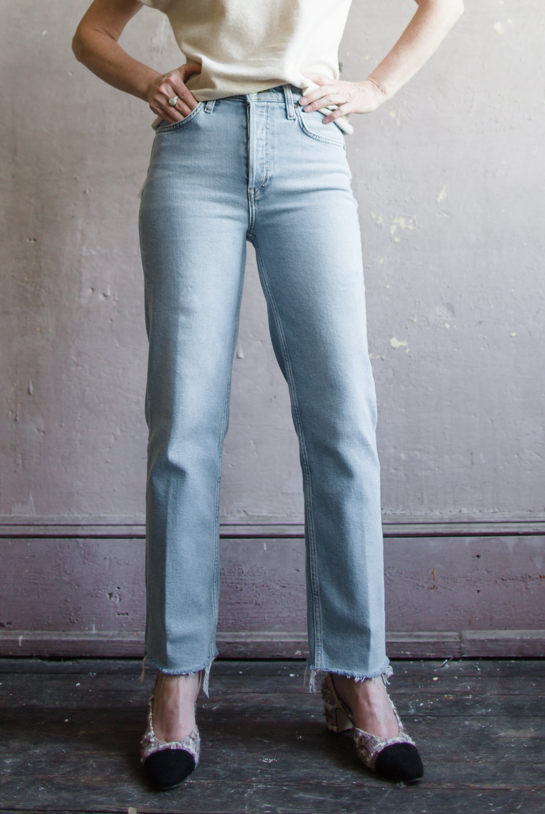 Image featuring a woman wearing Re/Done 70's denim straight leg jean with cropped inseam; in comfort stretch denim, a classic button fly, and a raw hem.