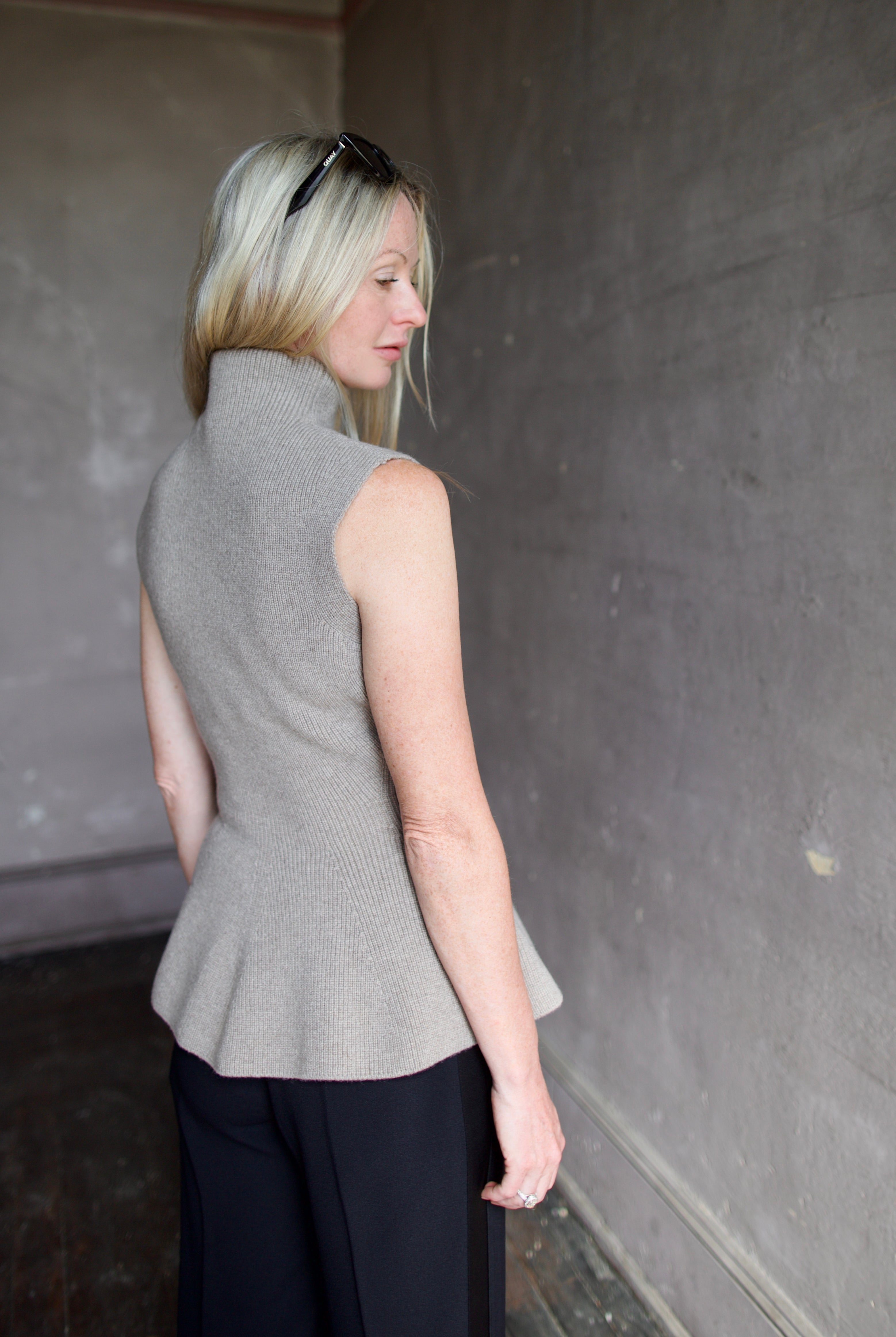 Model wearing luxury Rohe sculptural sleeveless knitted top with refined sophisticated modern silhouette for premium quality neutral taupe top
