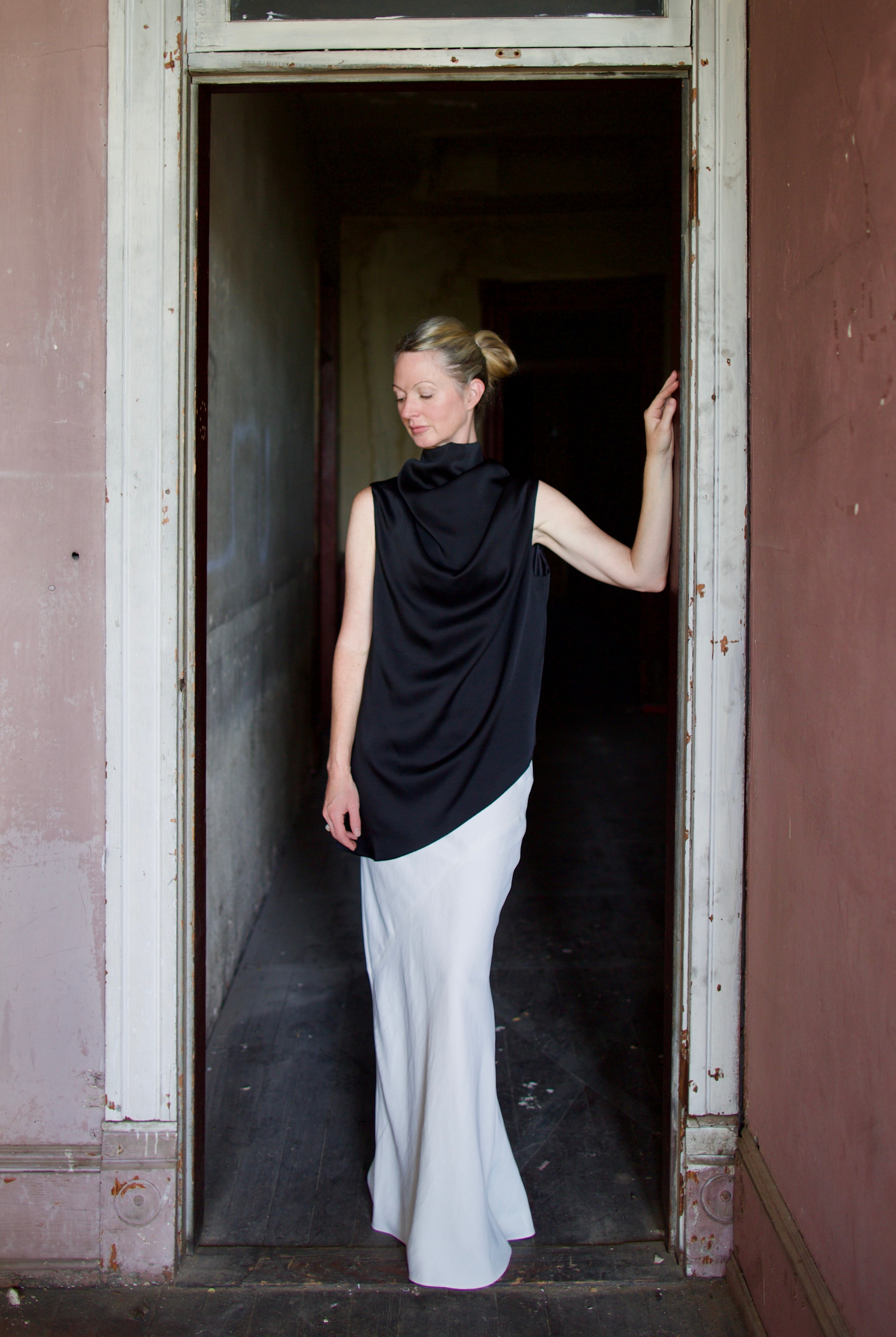Model wearing black sleeveless satin top with expertly crafted draping by luxury modern designer Rohe