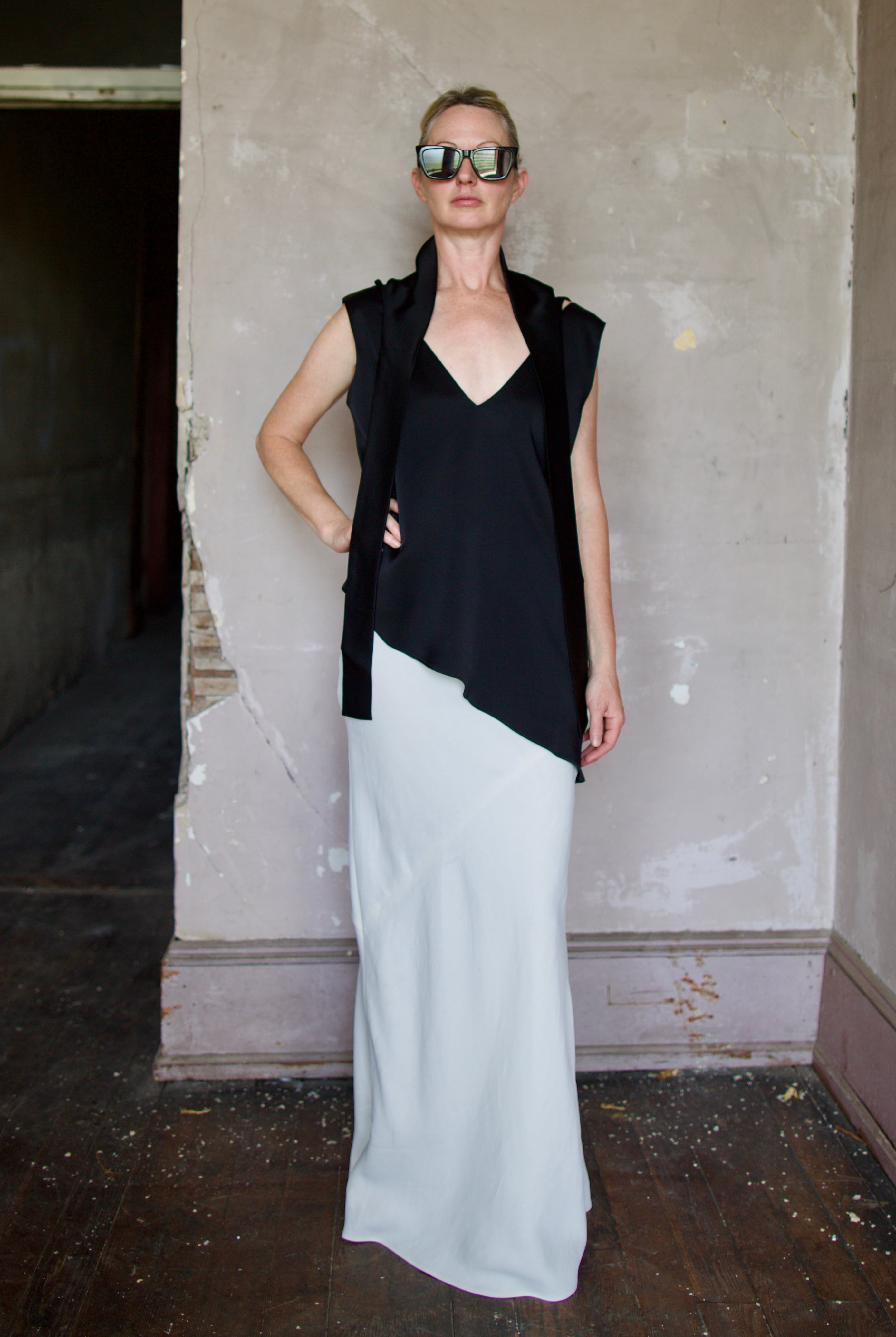Model wearing reversible black sleeveless satin top with expertly crafted draping by luxury modern designer Rohe
