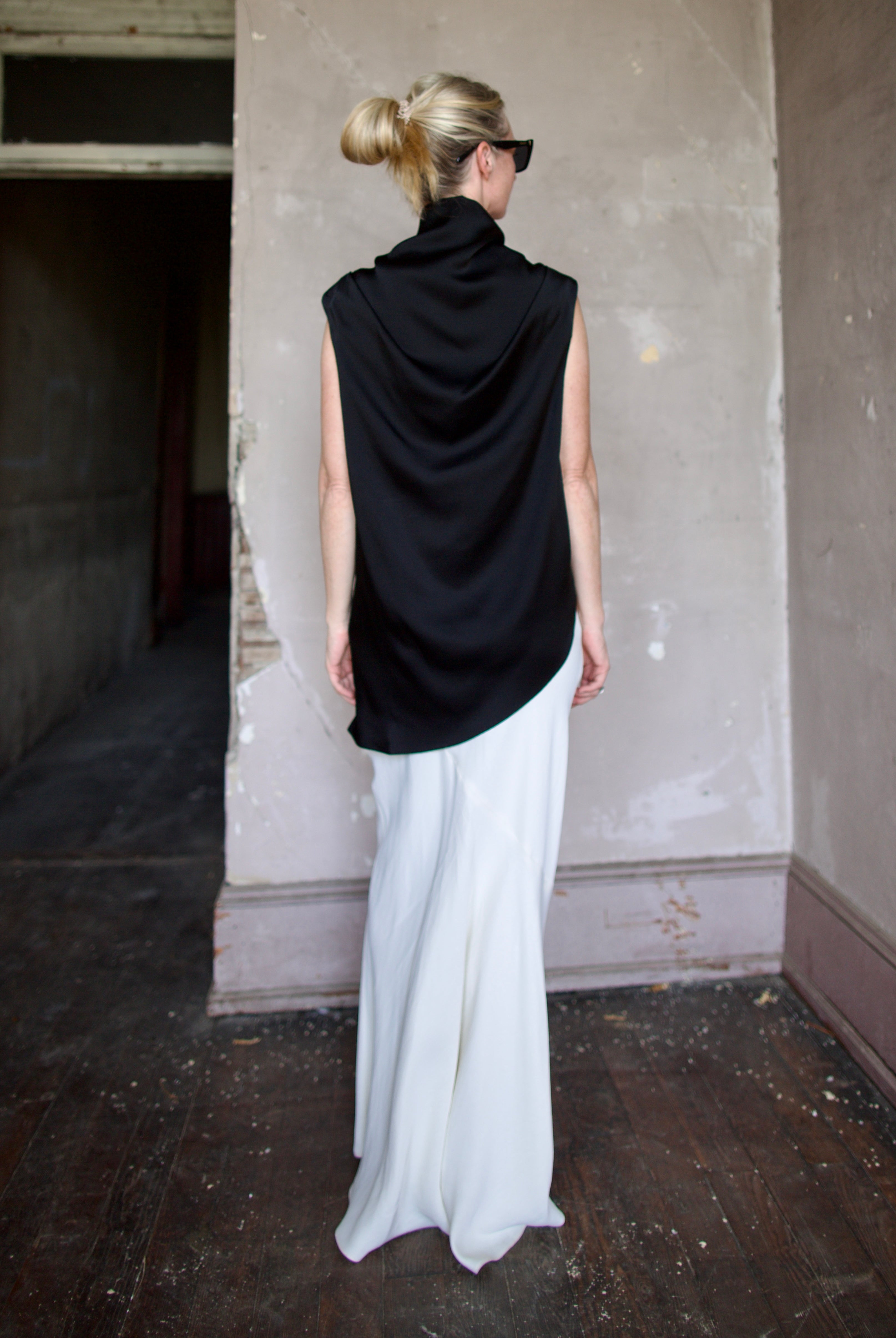 Model wearing black sleeveless satin top with expertly crafted draping by luxury modern designer Rohe
