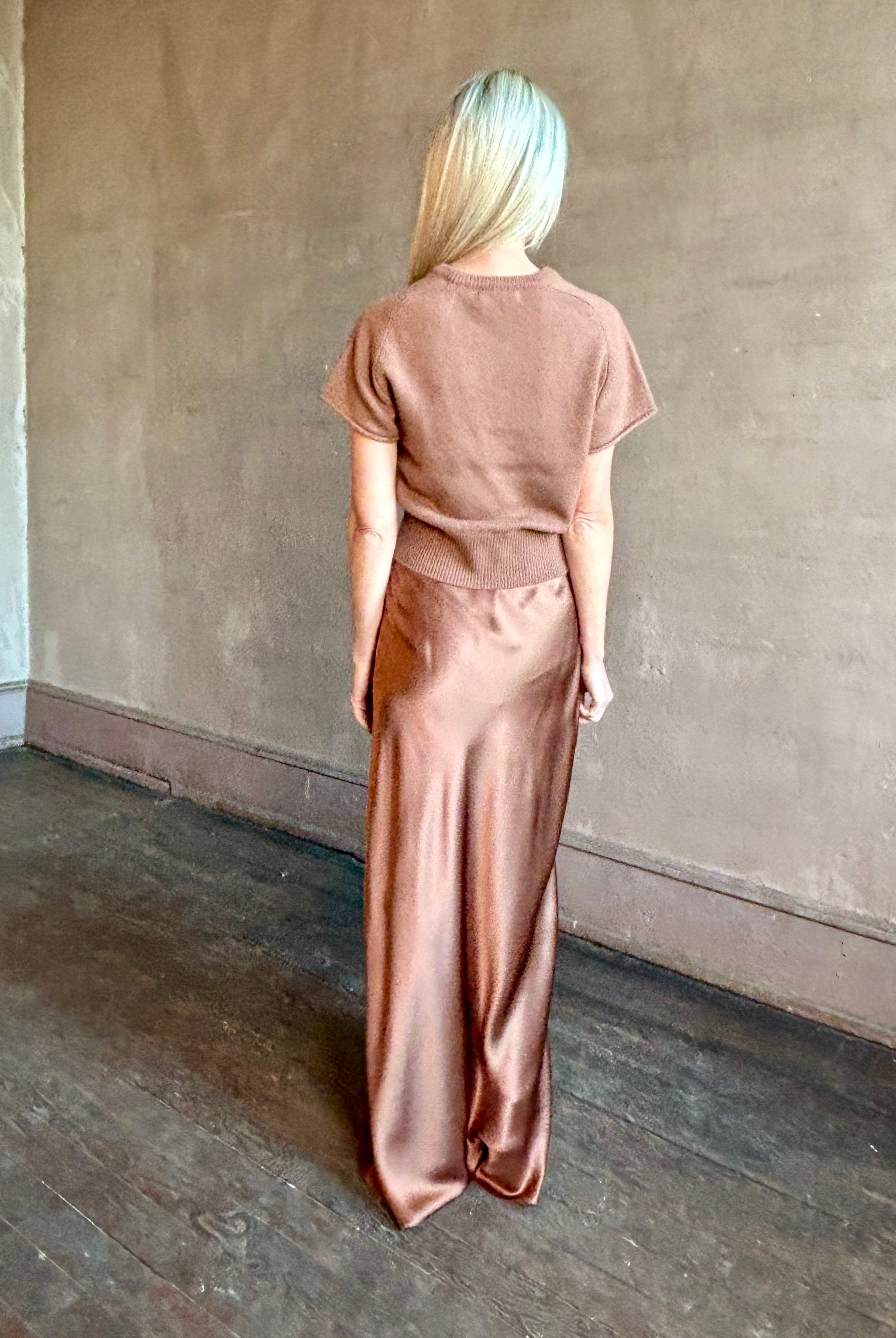 Woman wearing luxury brand SABLYN Grace Scallop Trim Bias Cut silk Maxi Pull On Skirt in neutral copper tone