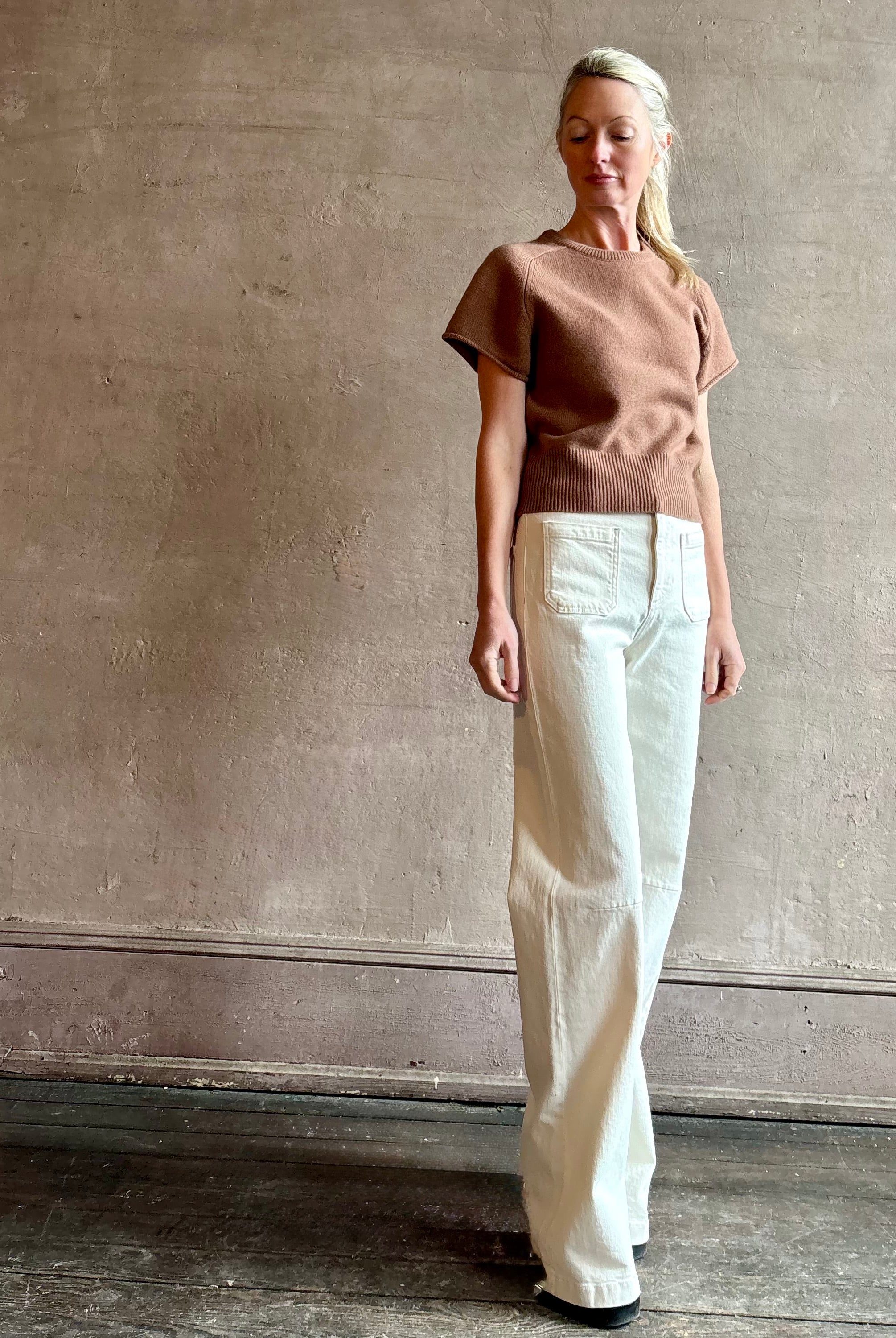 Woman wearing luxury women's brand SABLYN Jones Saddle Raglan Cashmere Sweater with crew neck and fitted waistband