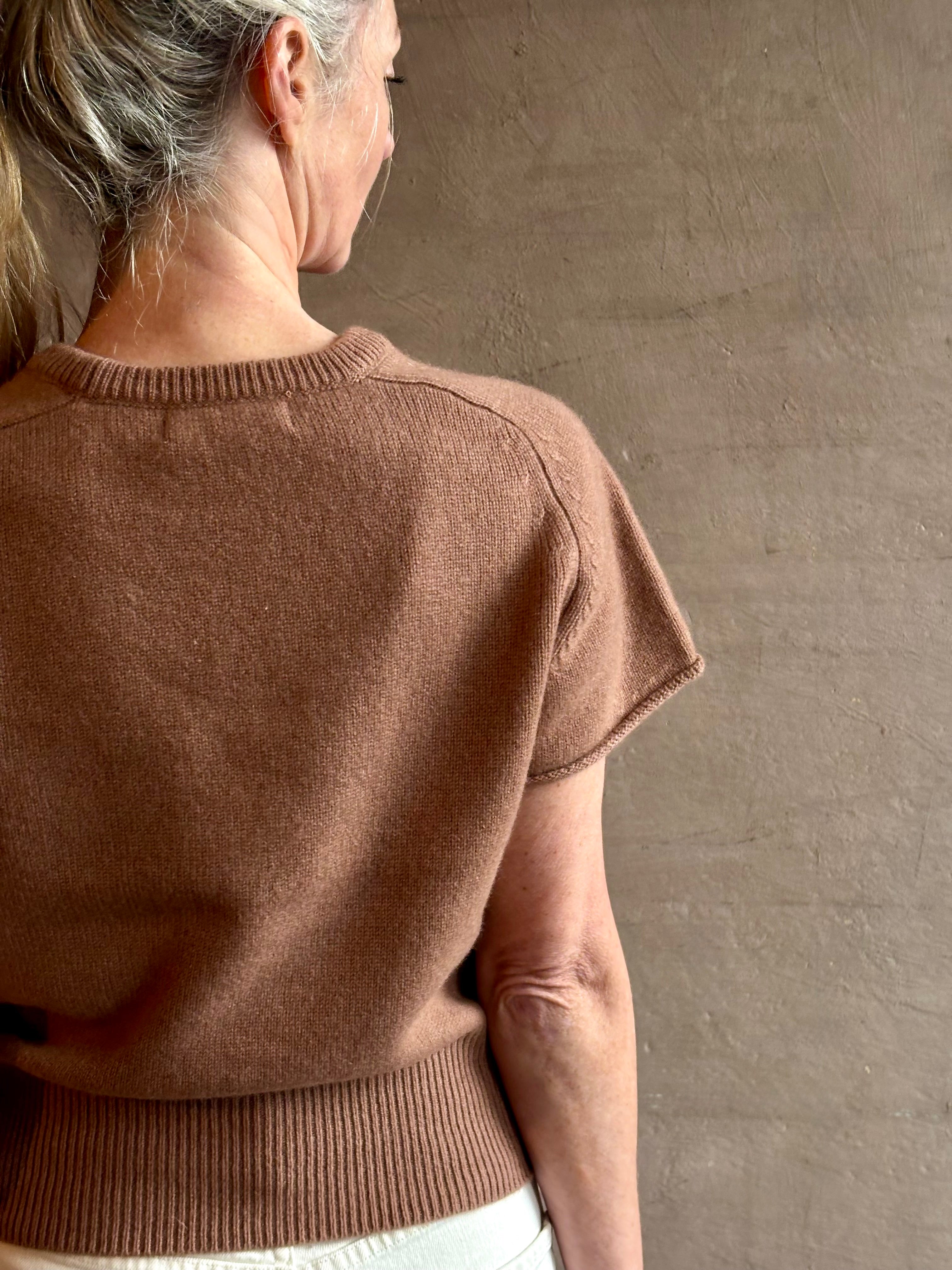 Woman wearing elegant luxury brand SABLYN Jones Saddle Raglan Cashmere Sweater in a neutral copper tone