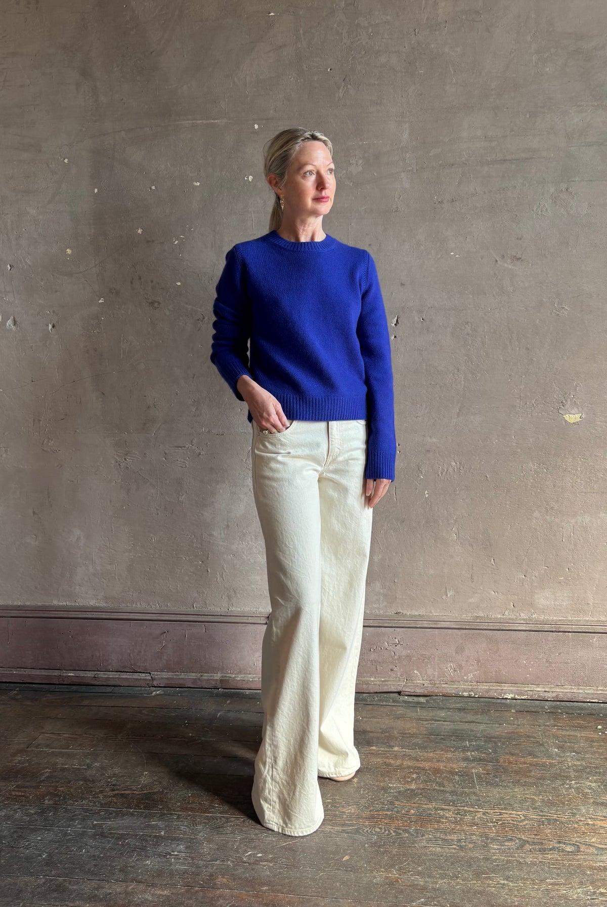 Mature woman wearing a vibrant cobalt blue Sablyn crewneck knit shrunken crewneck long sleeve cashmere sweater