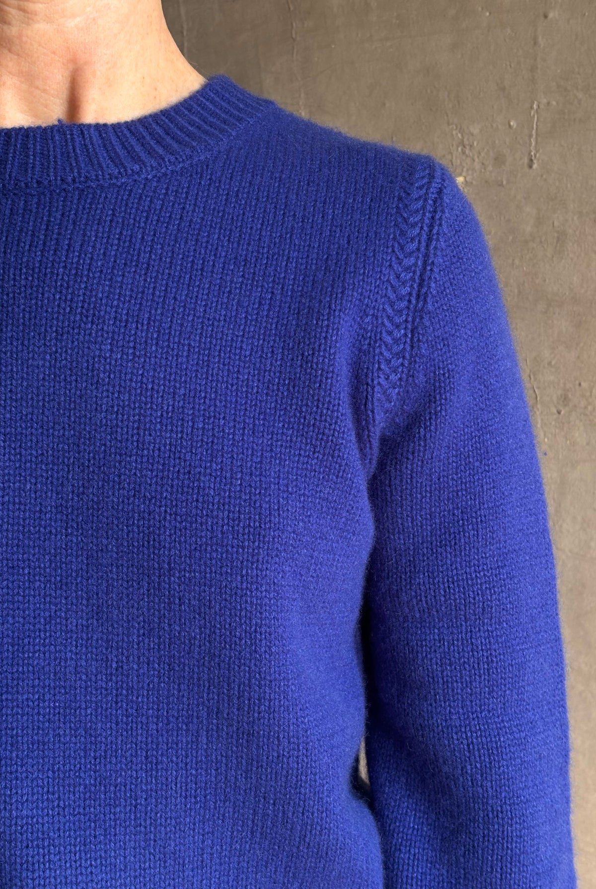 Mature woman wearing a vibrant cobalt blue Sablyn crewneck knit shrunken crewneck long sleeve cashmere sweater