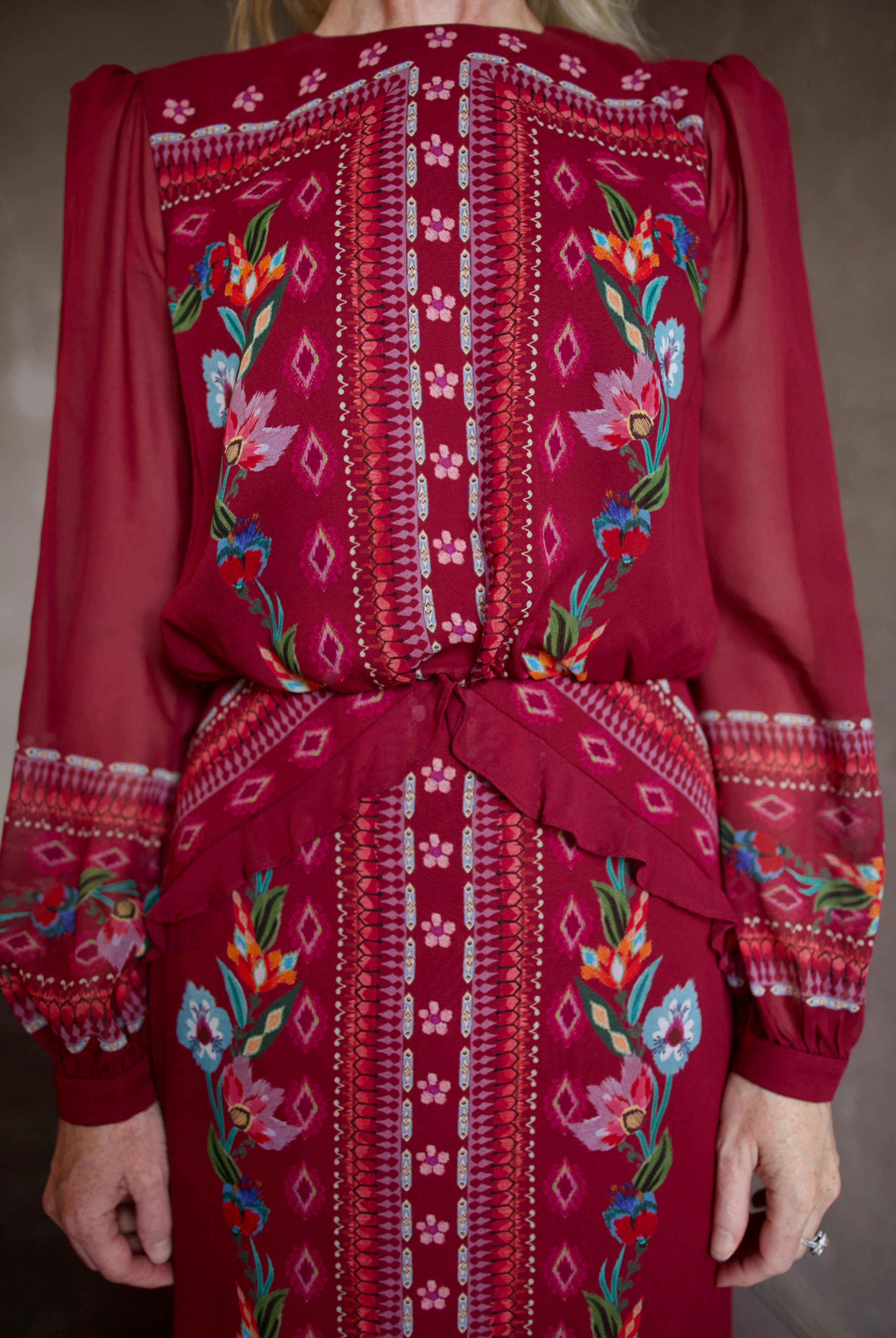 Model wearing Saloni Isa Long-C Dress in Cordia Vines. Dress features sophisticated silk fabrication with elegant long sleeves, delicate ruffle detailing, and intricate pattern styling.