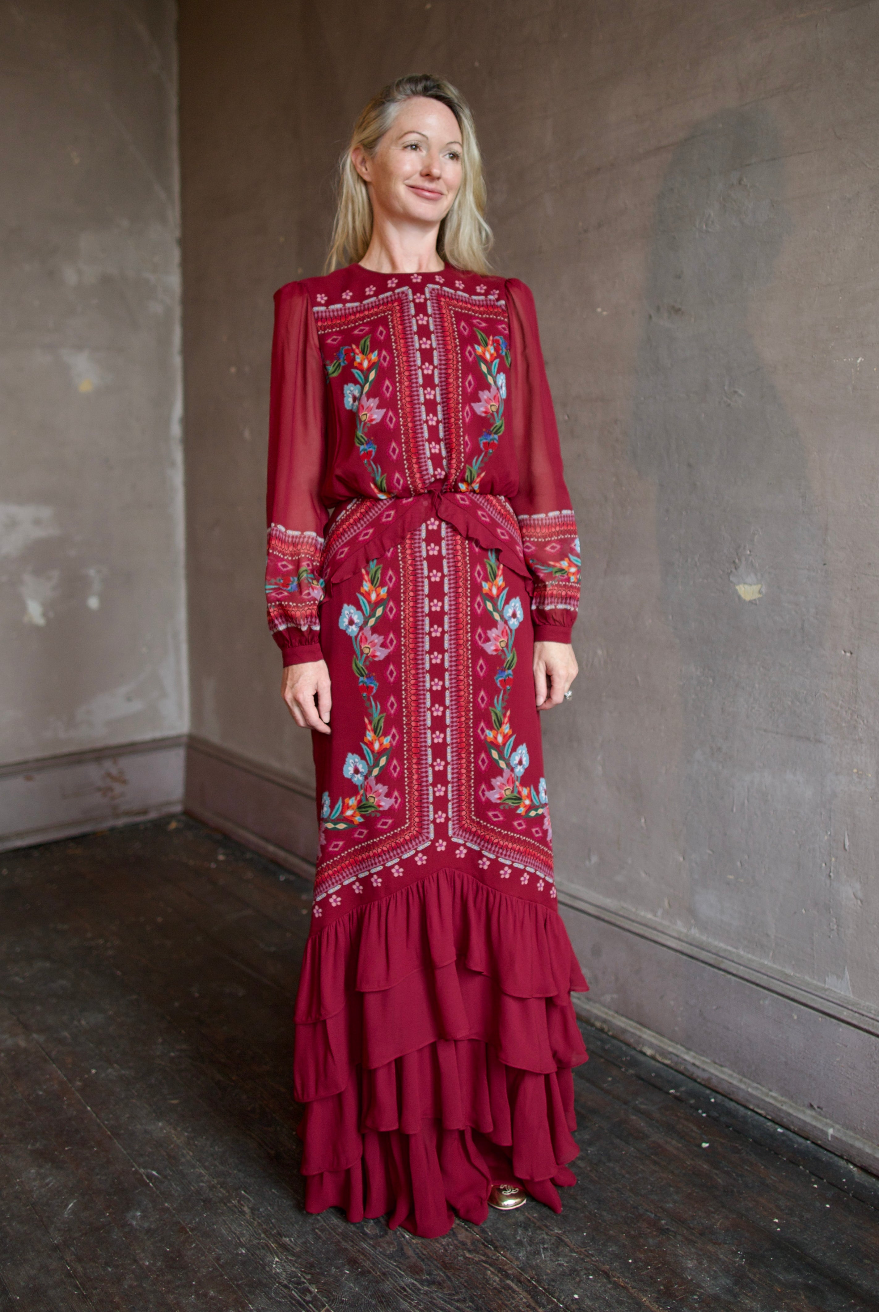 Model wearing Saloni Isa Long-C Dress in Cordia Vines. Dress features sophisticated silk fabrication with elegant long sleeves, delicate ruffle detailing, and intricate pattern styling.