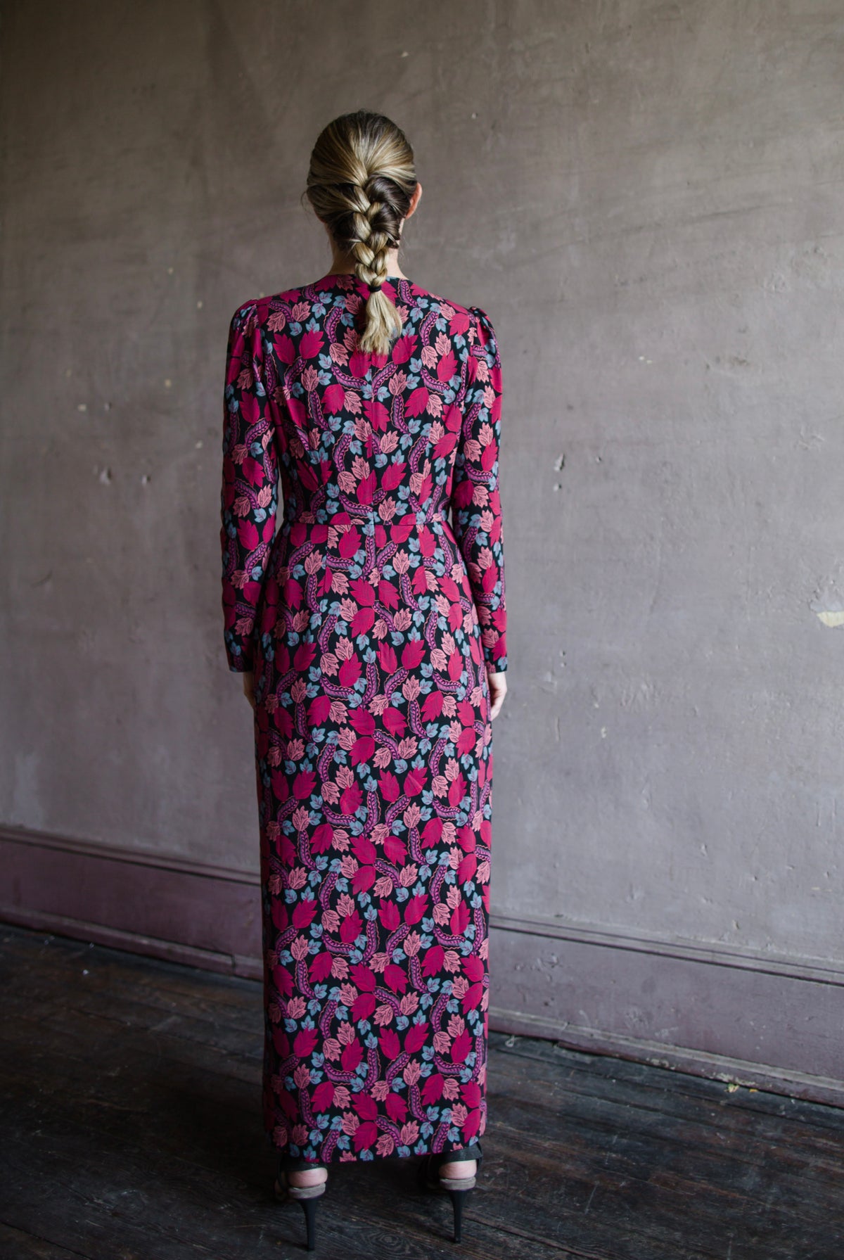 Image featuring a woman wearing the Jinx-C silk dress by Saloni with a crew neckline, long sleeves, and velvet trim cutouts down the front in a leaf print