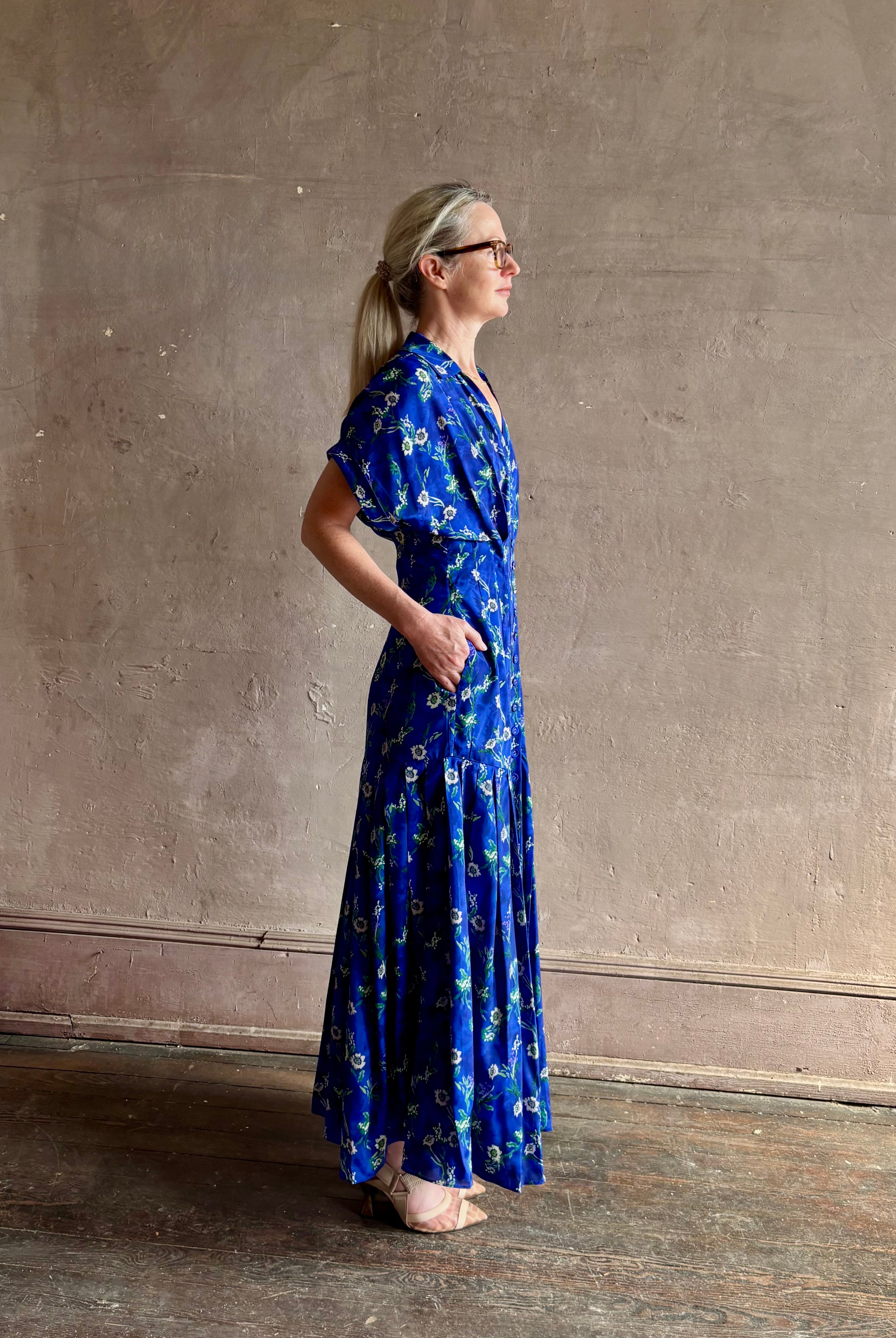 Woman wearing Saloni silk maxi Riya dress with short sleeves bouson top drop waist v-neck button front cobalt