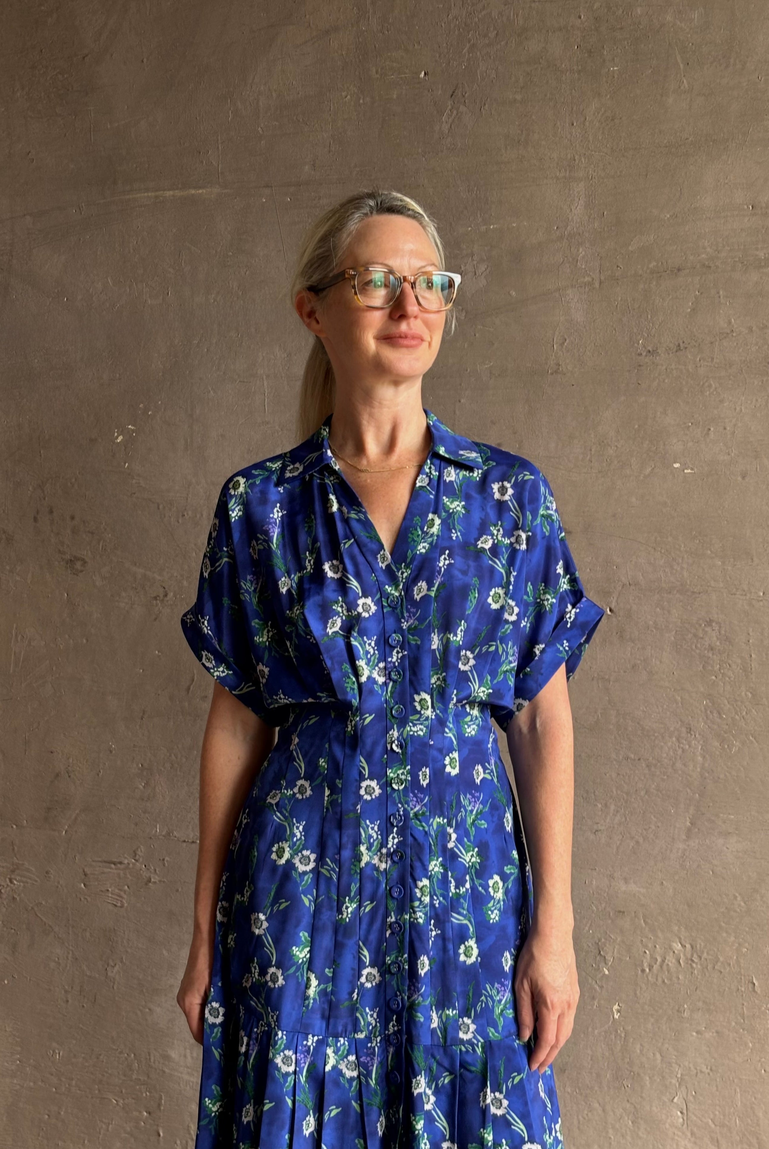 Woman wearing Saloni silk maxi Riya dress with short sleeves bouson top drop waist v-neck button front cobalt